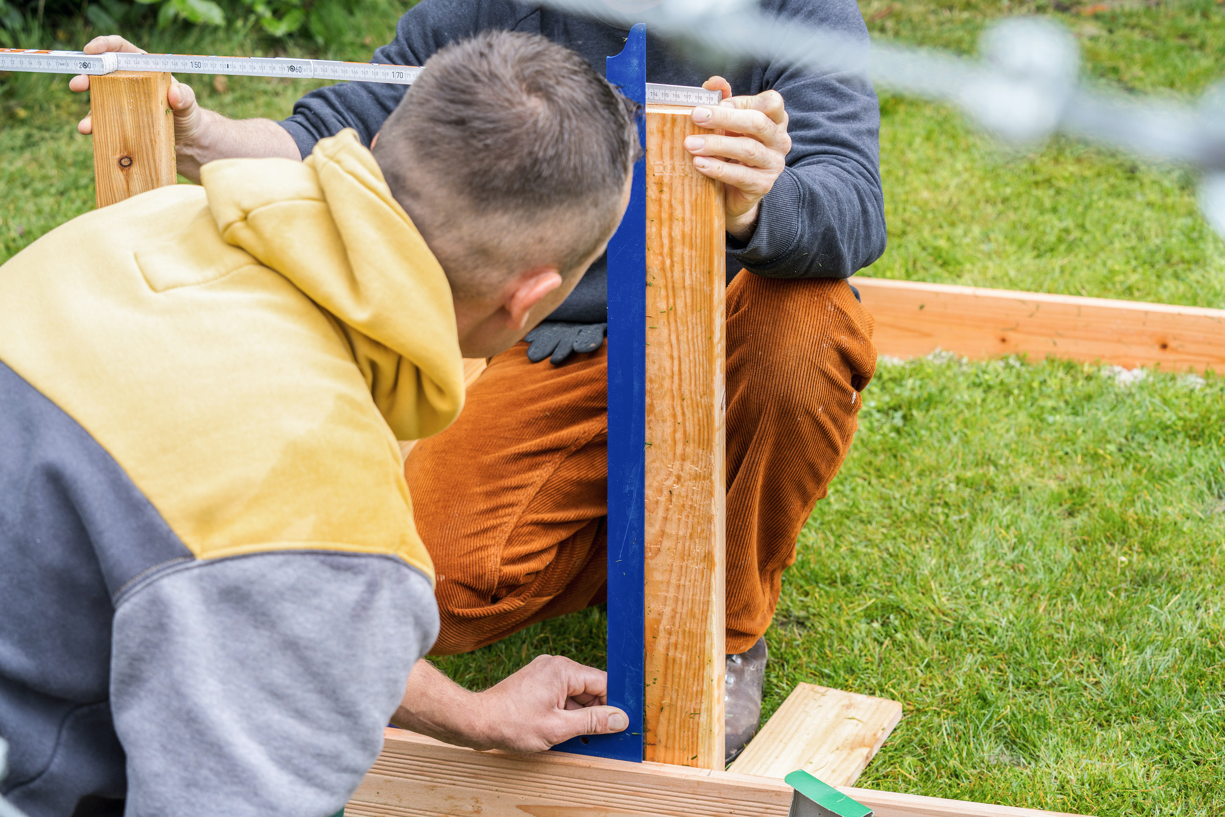 Due uomini misurano una trave
