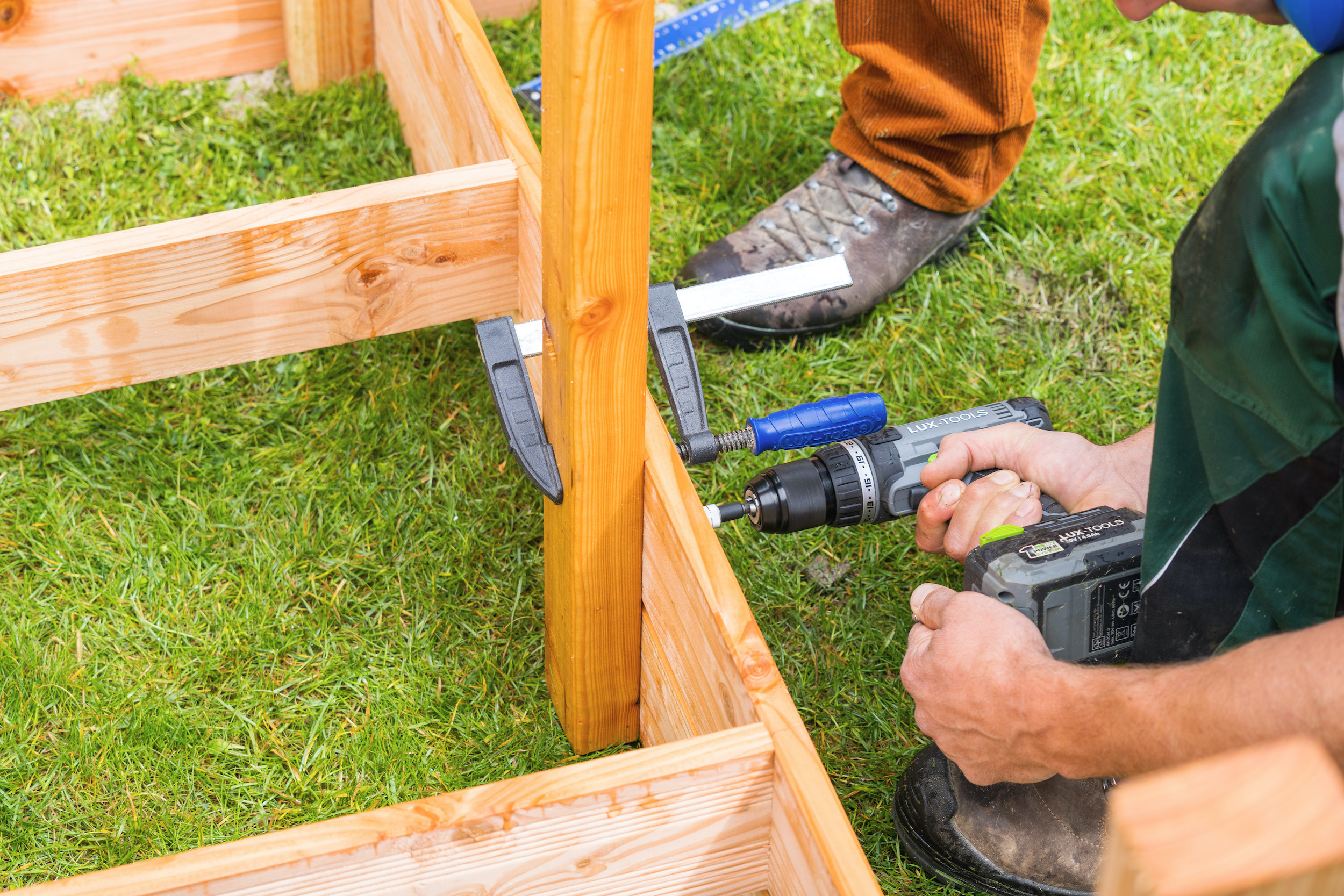 Mani avvitano una trave alla struttura di base