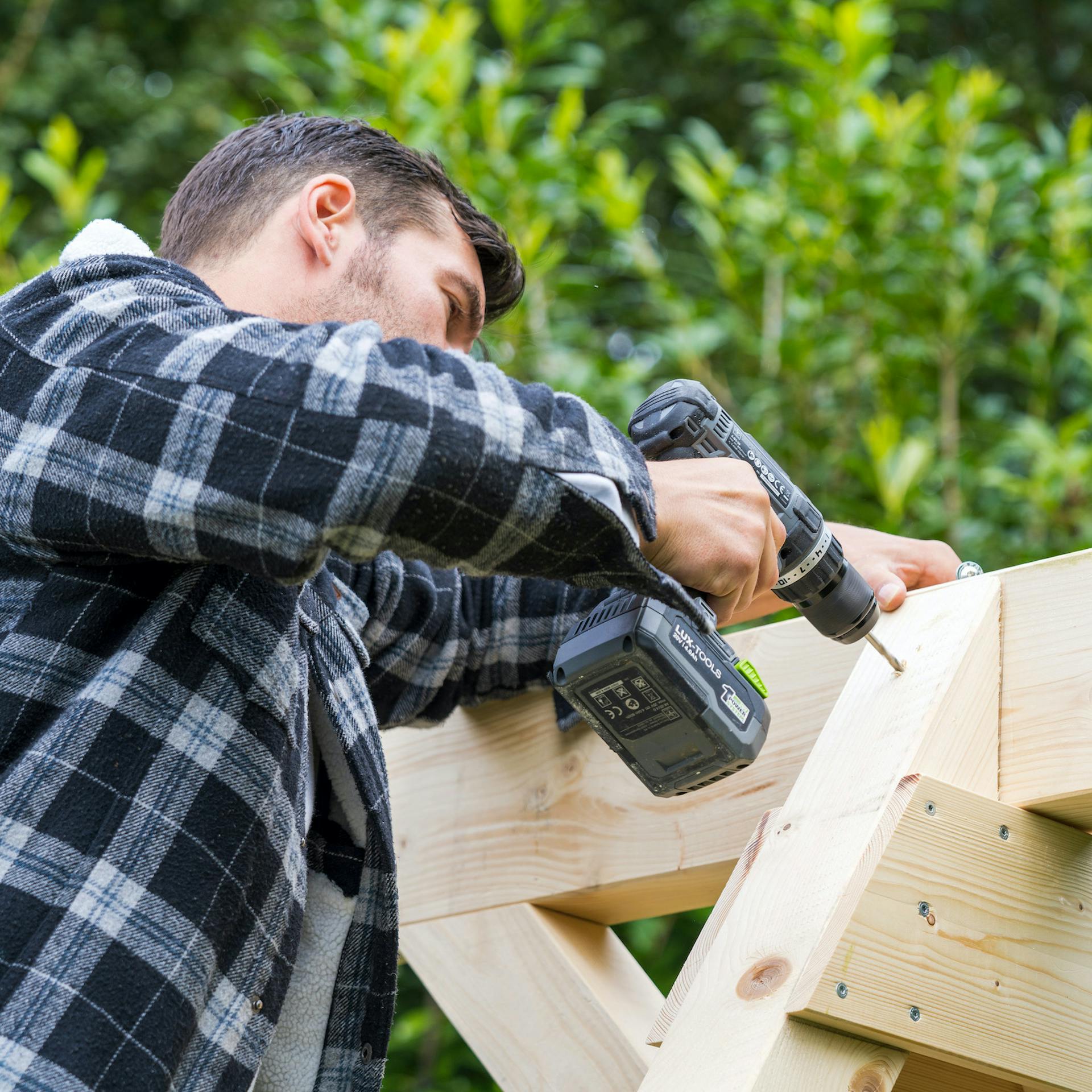 Összecsavarozzák a hintaállványt.