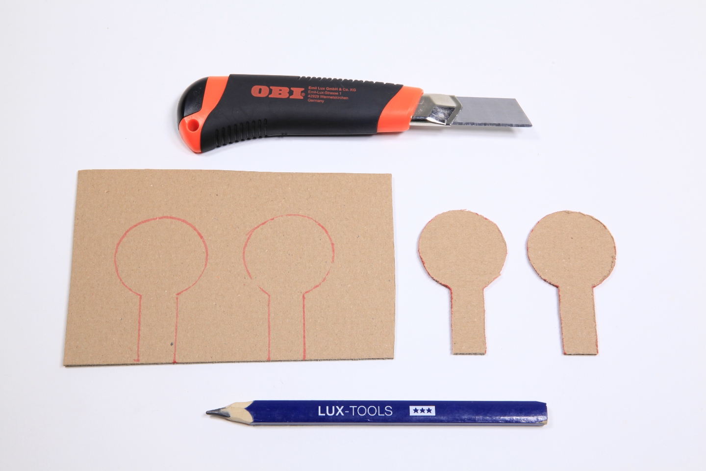 Ziele für Schießbude auf Karton aufgemalt neben Cuttermesser und Bleistift