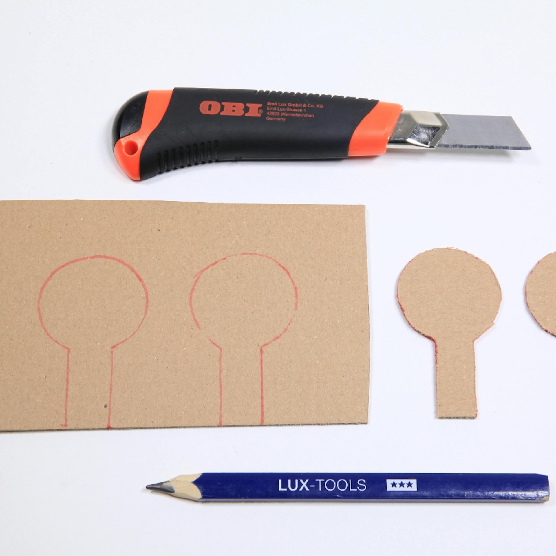 Ziele für Schießbude auf Karton aufgemalt neben Cuttermesser und Bleistift