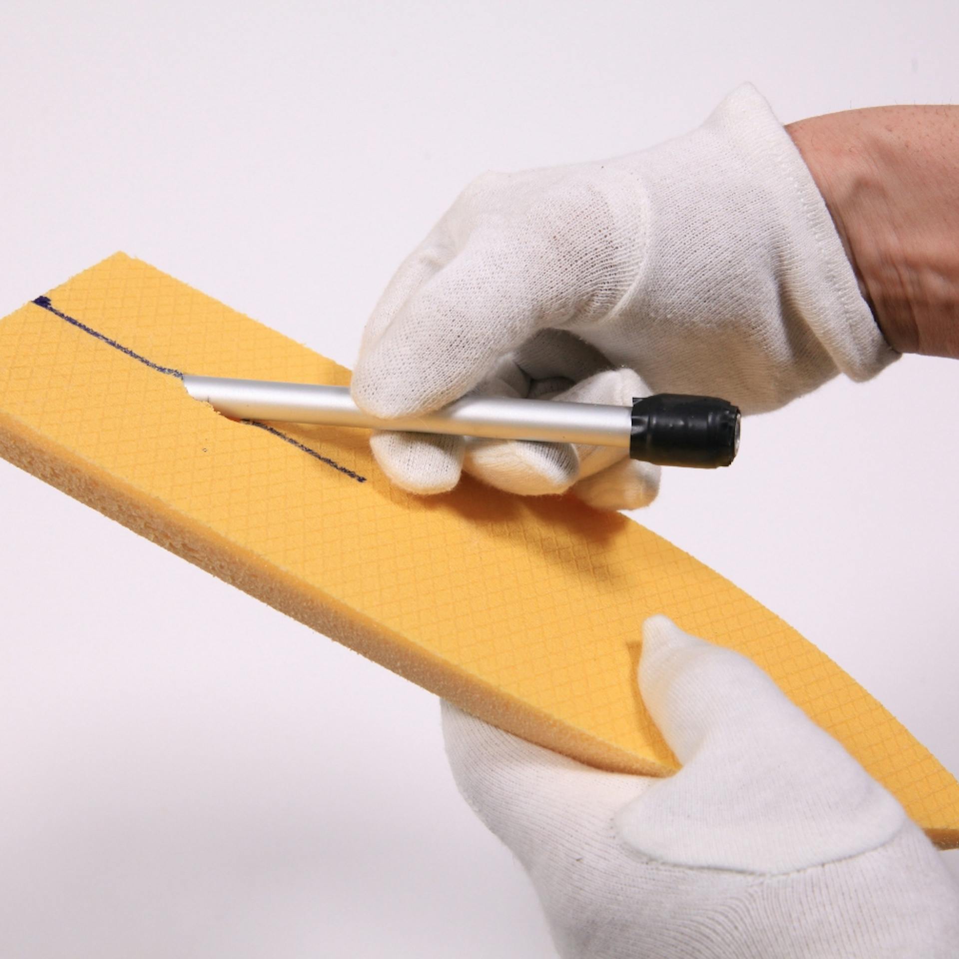 Person zieht Aluröhrchen durch Schiff-Form aus Dämmplatte