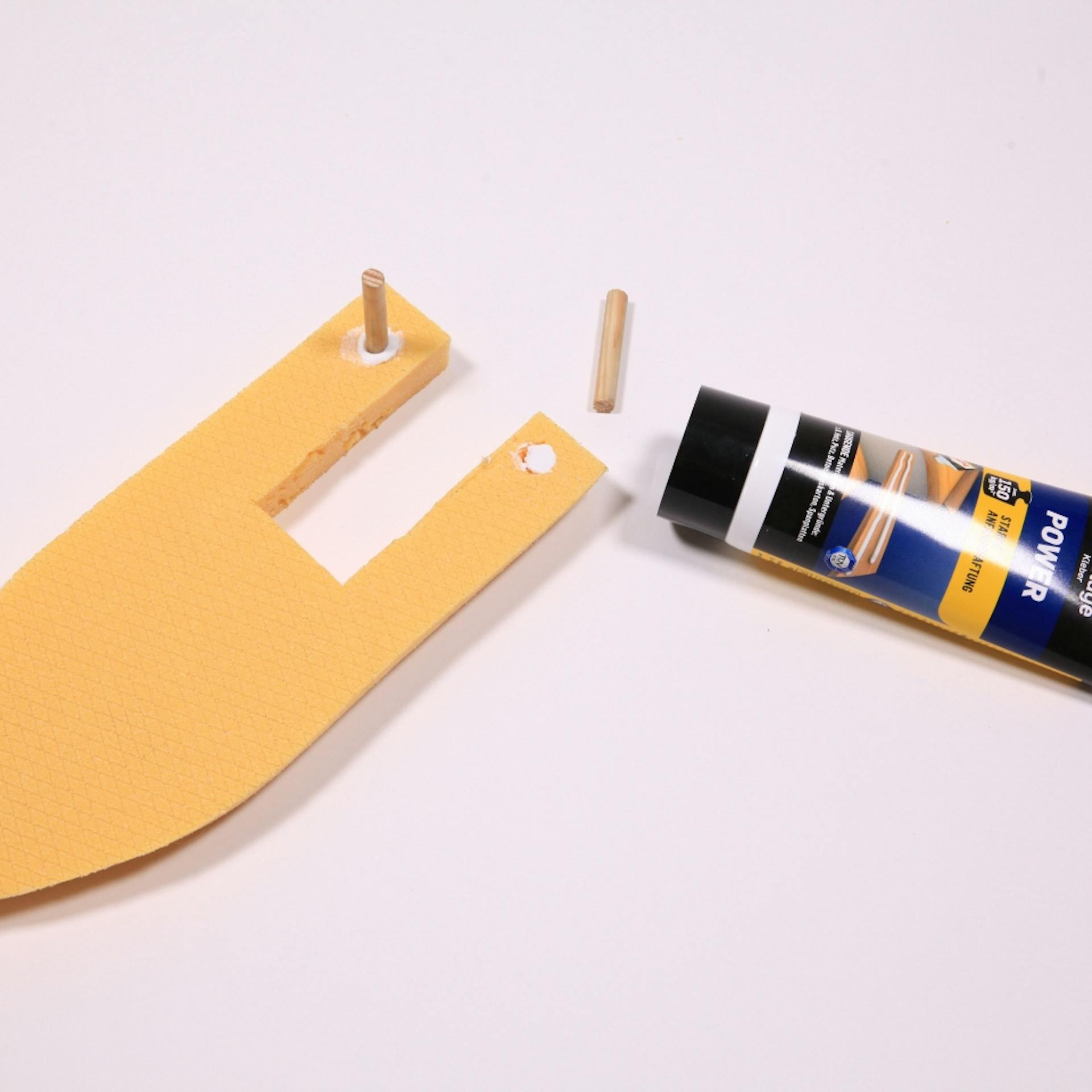 Schiff-Form aus Dämmplatte liegt neben Kleber und Holzstückchen