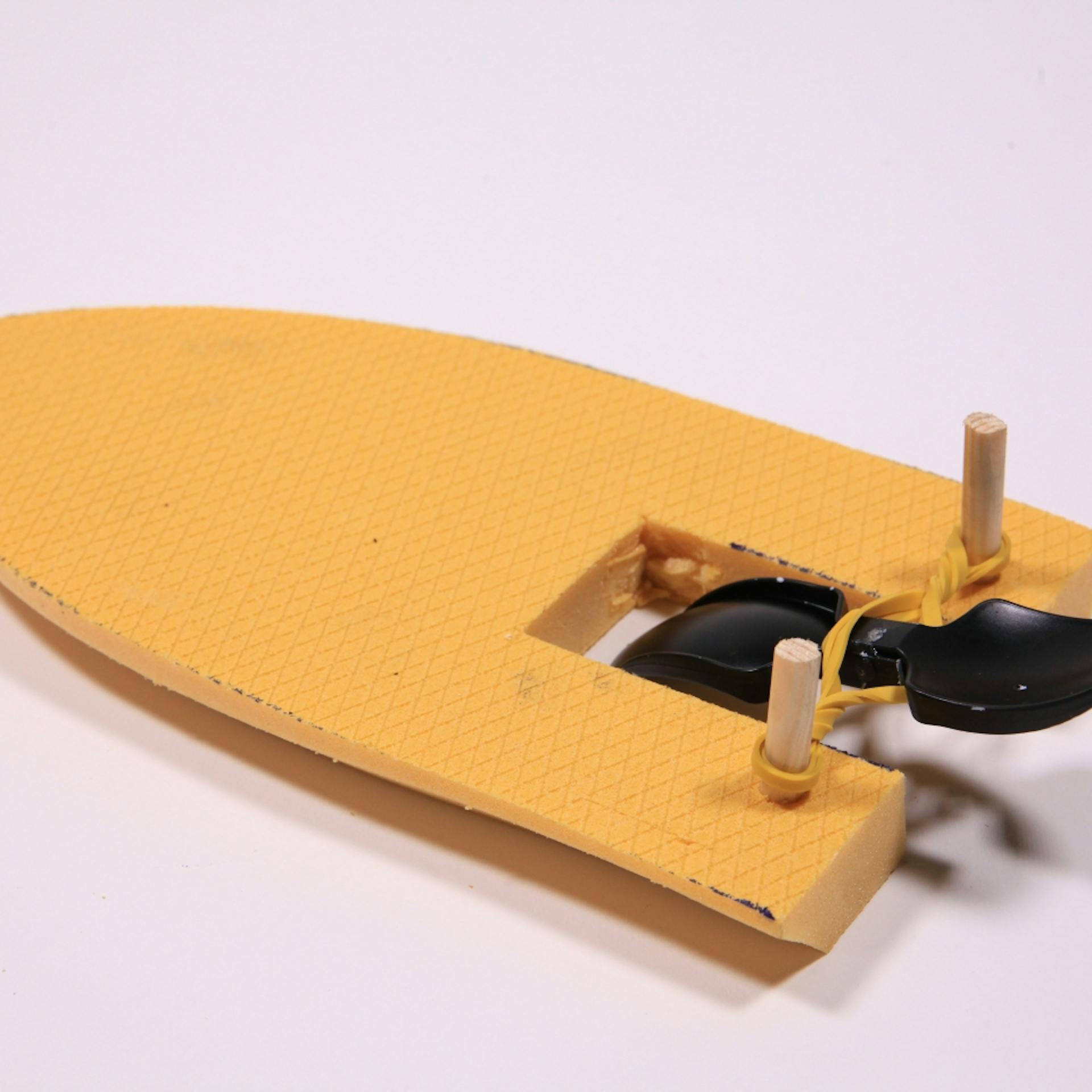 Plastiklöffel an Gummiband und Schiff-Form aus Dämmplatte