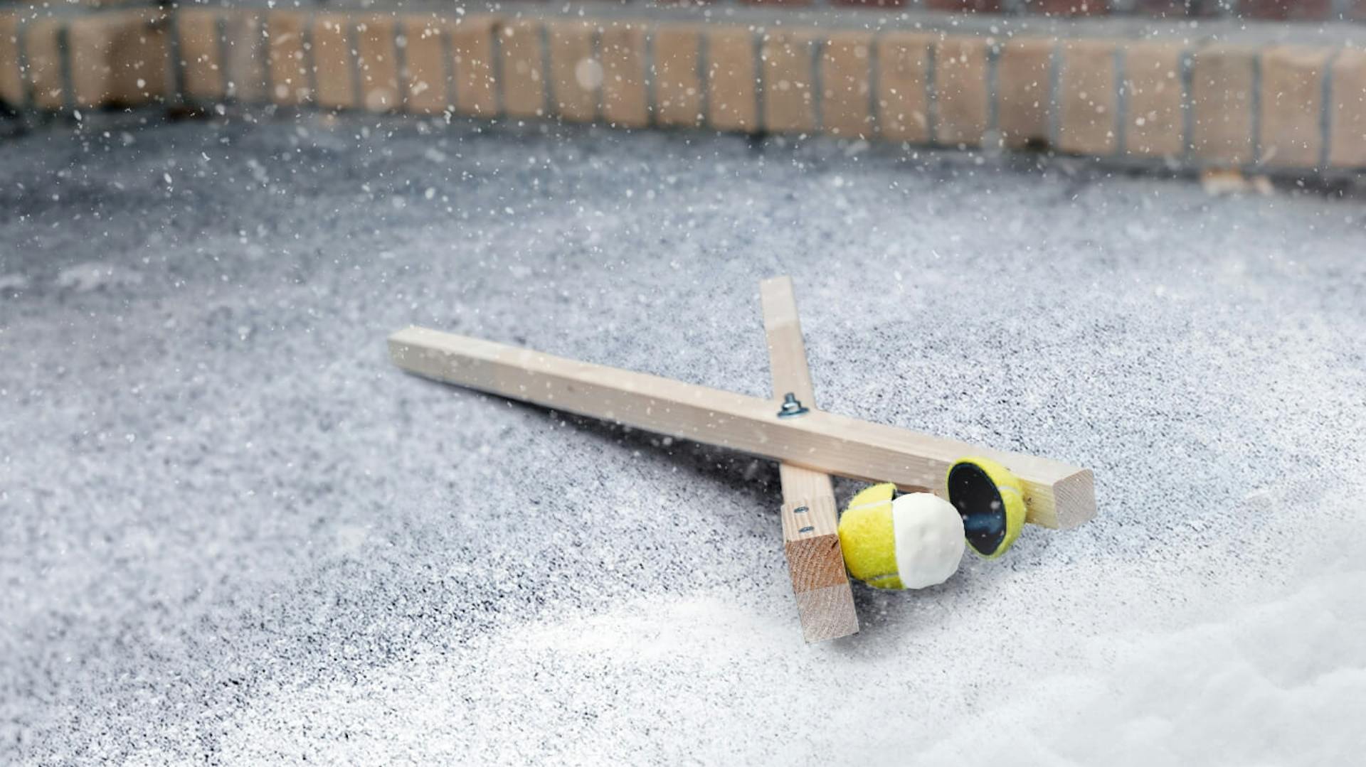 Die Schneeballzange liegt auf einem verschneiten Innenhof.