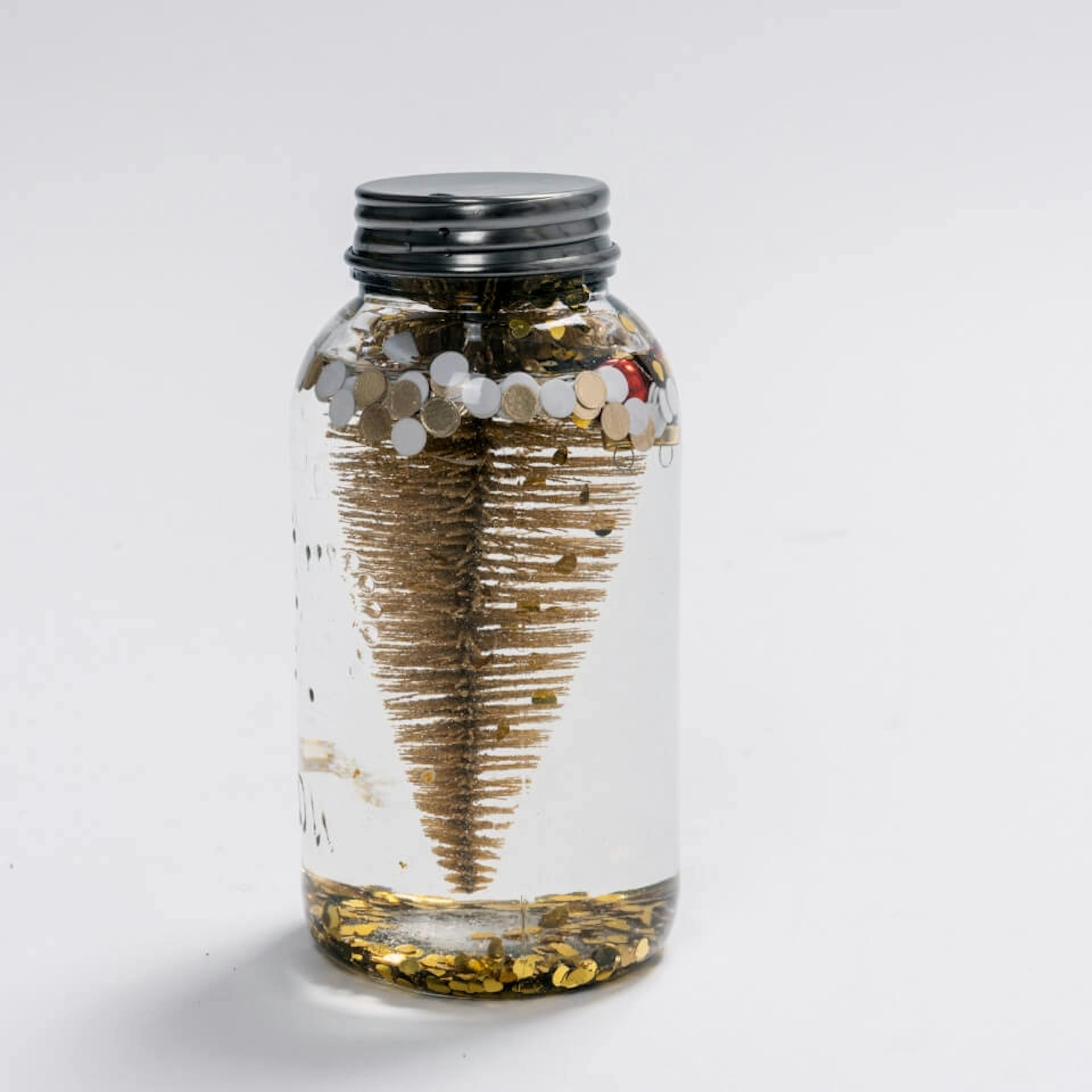 Il vasetto di marmellata è stato chiuso avvitando il coperchio per realizzare la palla di vetro con la neve fai da te.