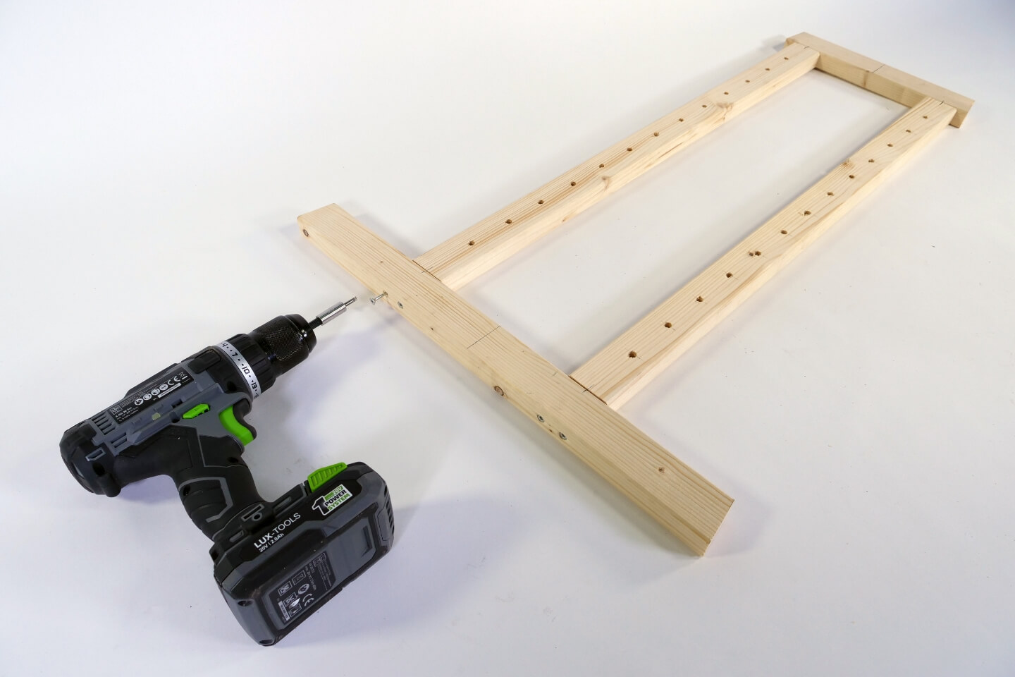 Holzleisten werden für eine Staffelei mit einem Akkuschrauber zusammengebaut.