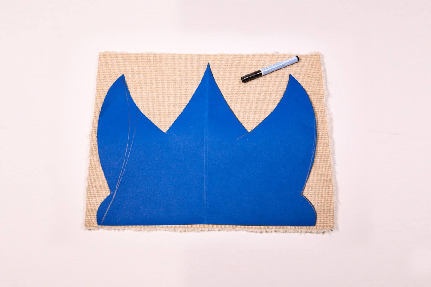 La sagoma a forma di corona accanto al pennarello sul tappeto.