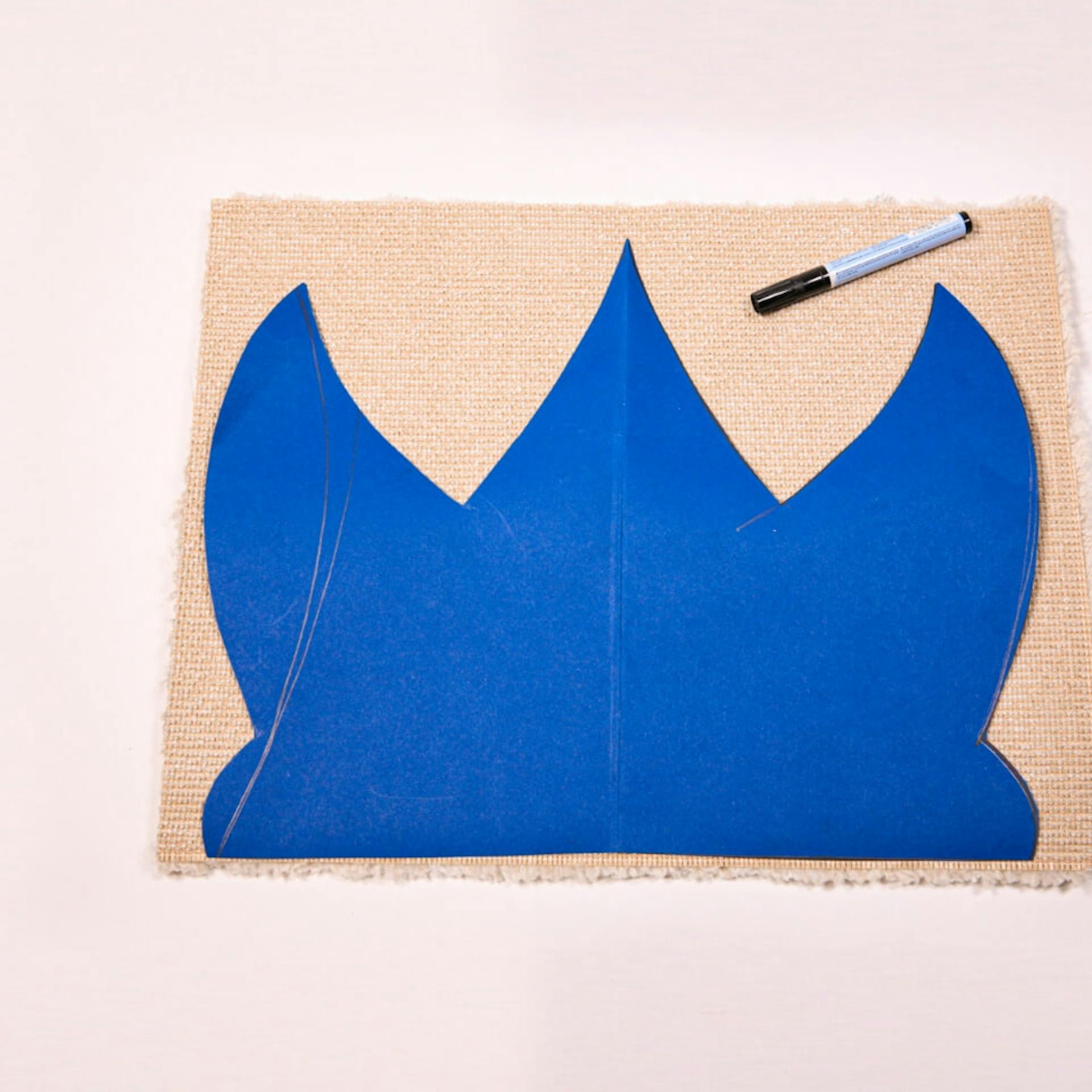 La sagoma a forma di corona accanto al pennarello sul tappeto.