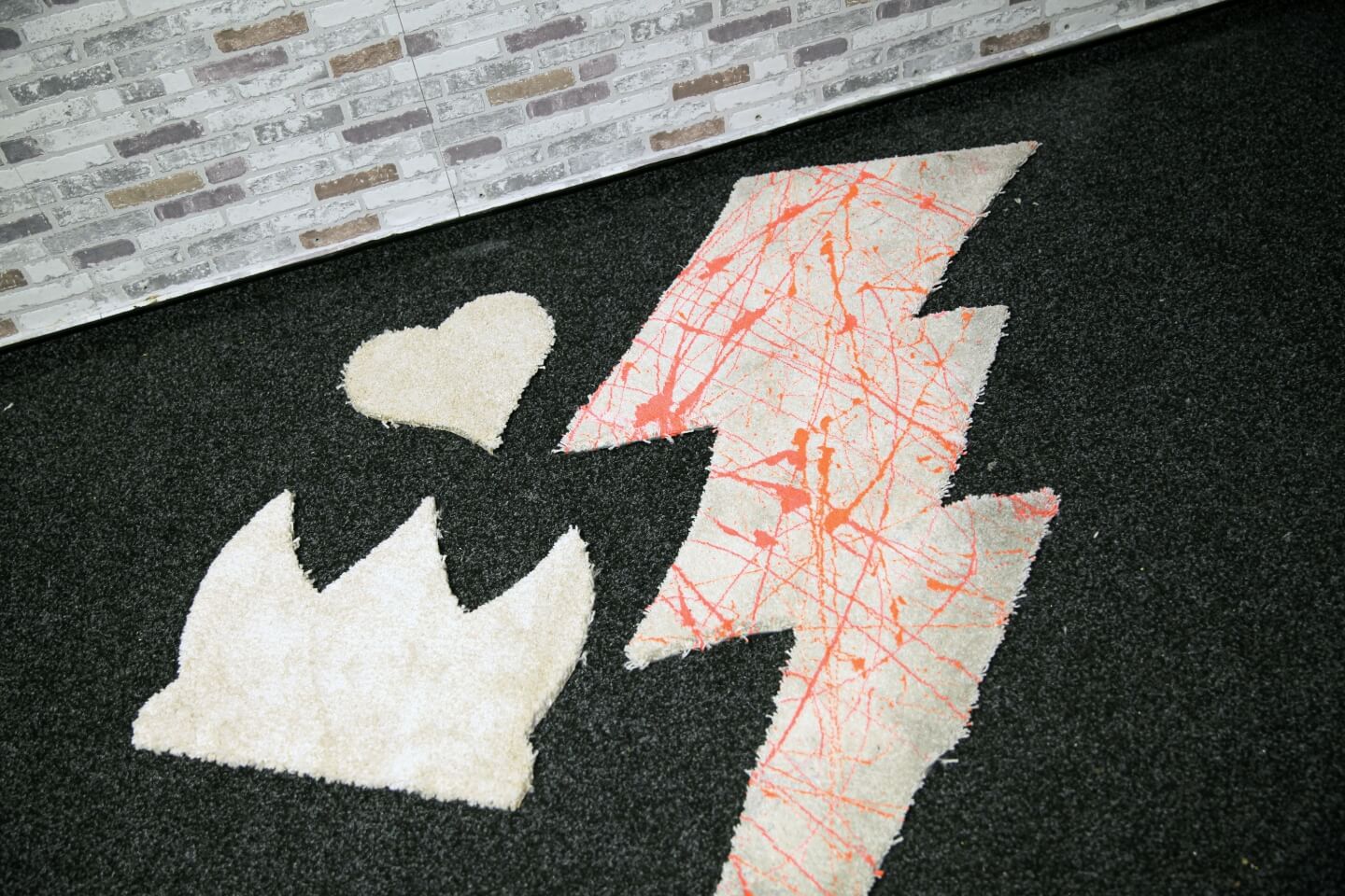 Tappeto a forma di lampo con schizzi di vernice arancione.