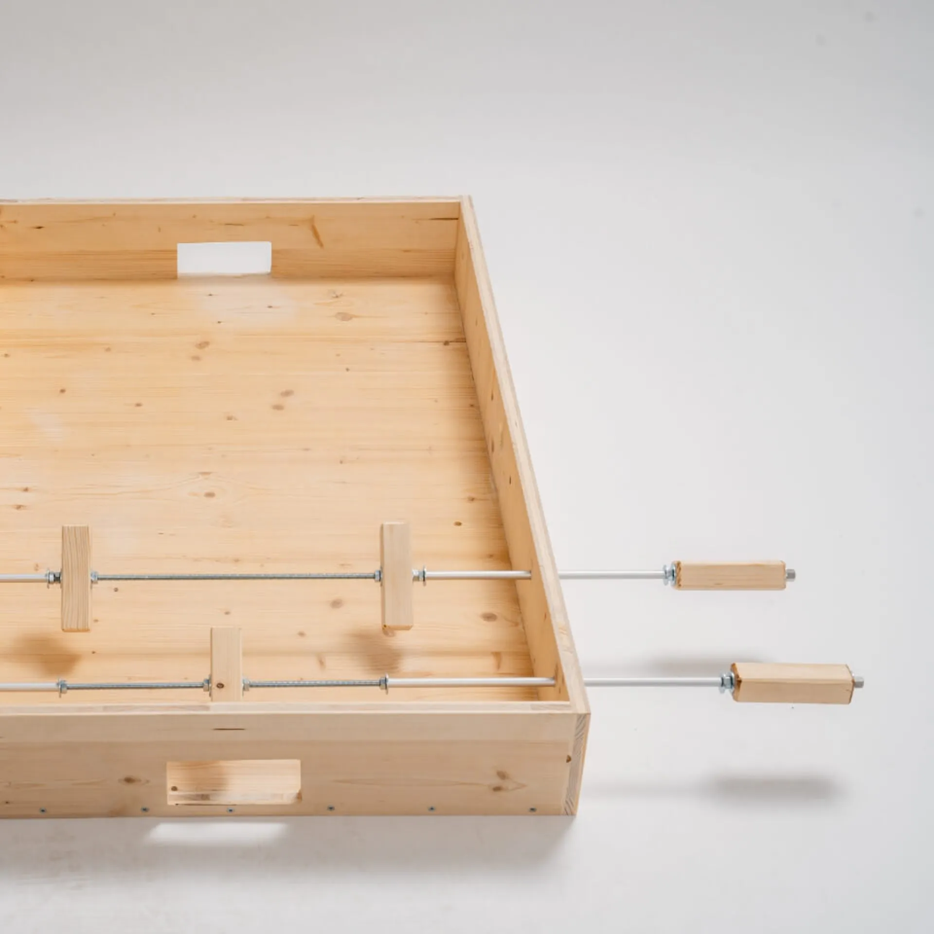 Stolní fotbal se dvěma vyrážecími tyčemi, brankářem a dvěma obránci.