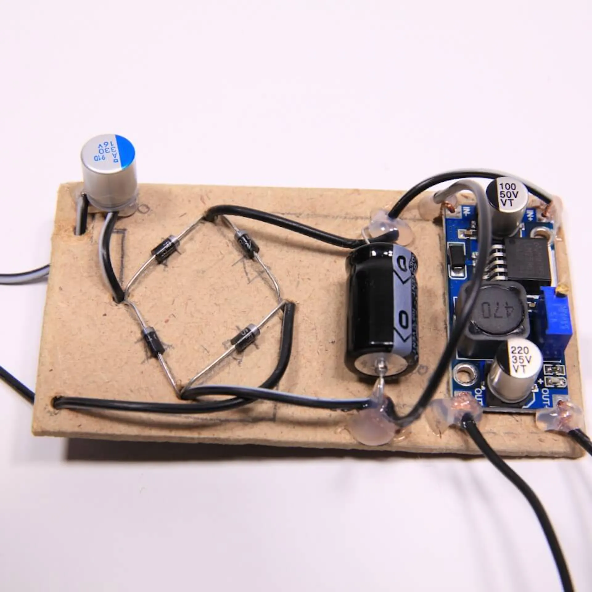 Step-Down-Modul auf Holzplatte befestigt. Zwei weitere Kabel an Step-Down-Modul befestigt.