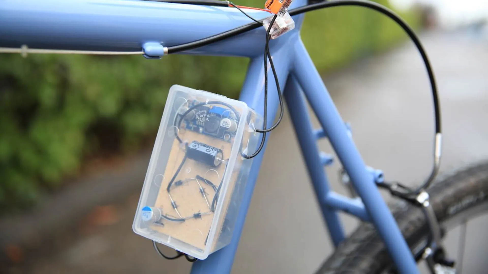 USB Ladegerät an einem blauen Fahrradrahmen befestigt.