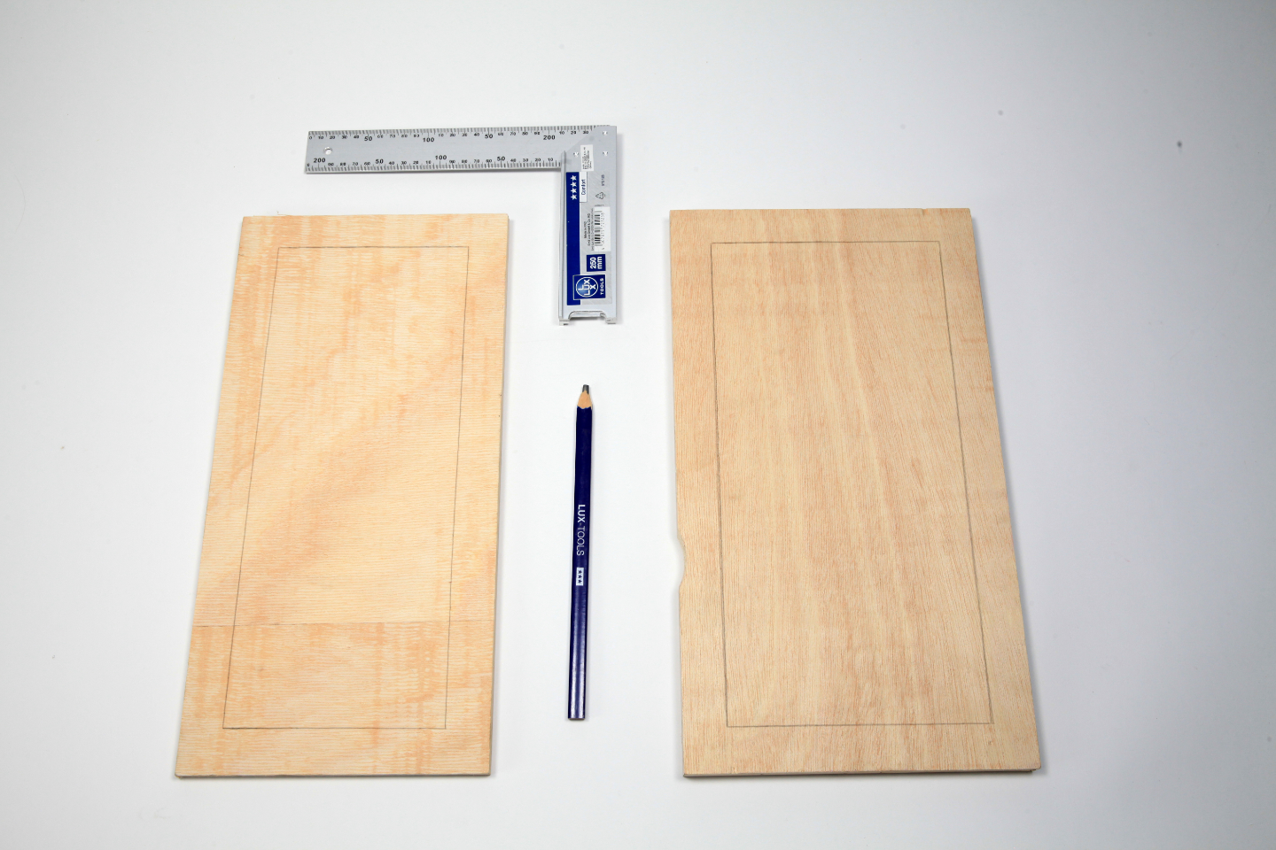 Zwei Holzbretter liegen neben Lineal und Bleistift mit aufgezeichneten Linien