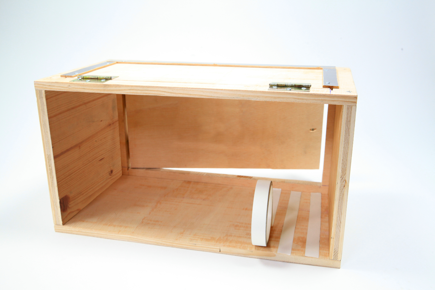 Box aus Holz mit weißen Klebebandstreifen auf Boden