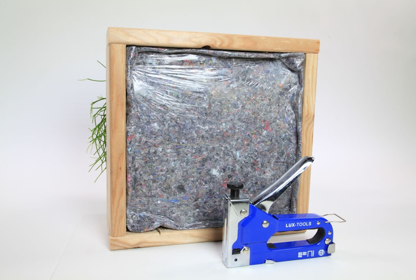 A függőleges kert, egy festőfilccel rögzített, hátoldala látható. Előtte egy tűzőgép található.