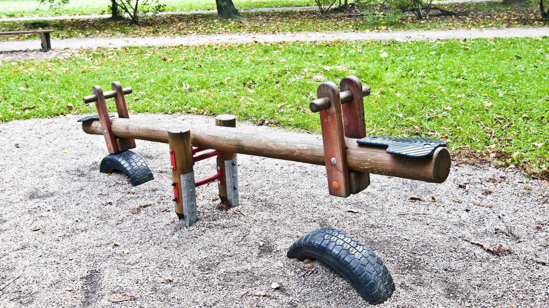 Holzwippe mit Sitzen und Gummireifen auf Sandfläche