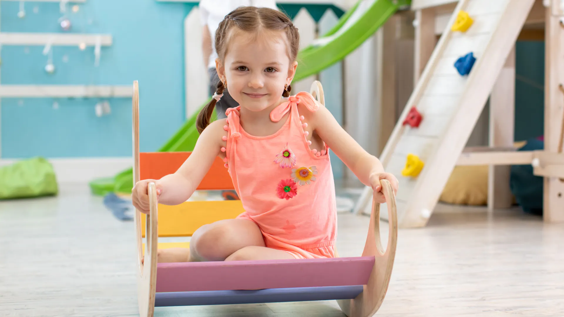 Una bambina su un dondolo arcobaleno