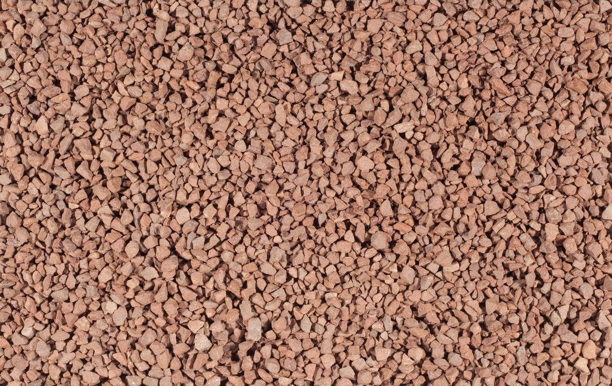 Rote Porphyrsteine als Befüllung von Gabionen.