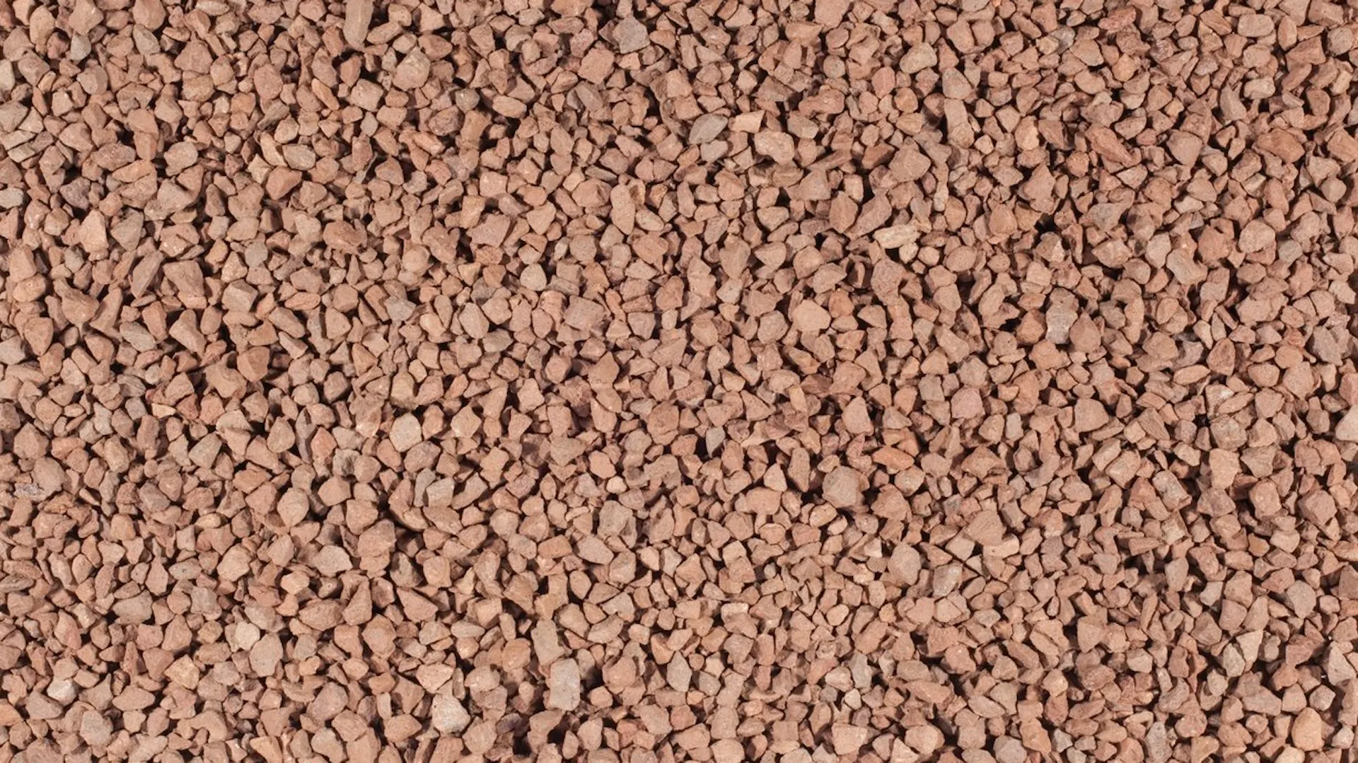 Rote Porphyrsteine als Befüllung von Gabionen.