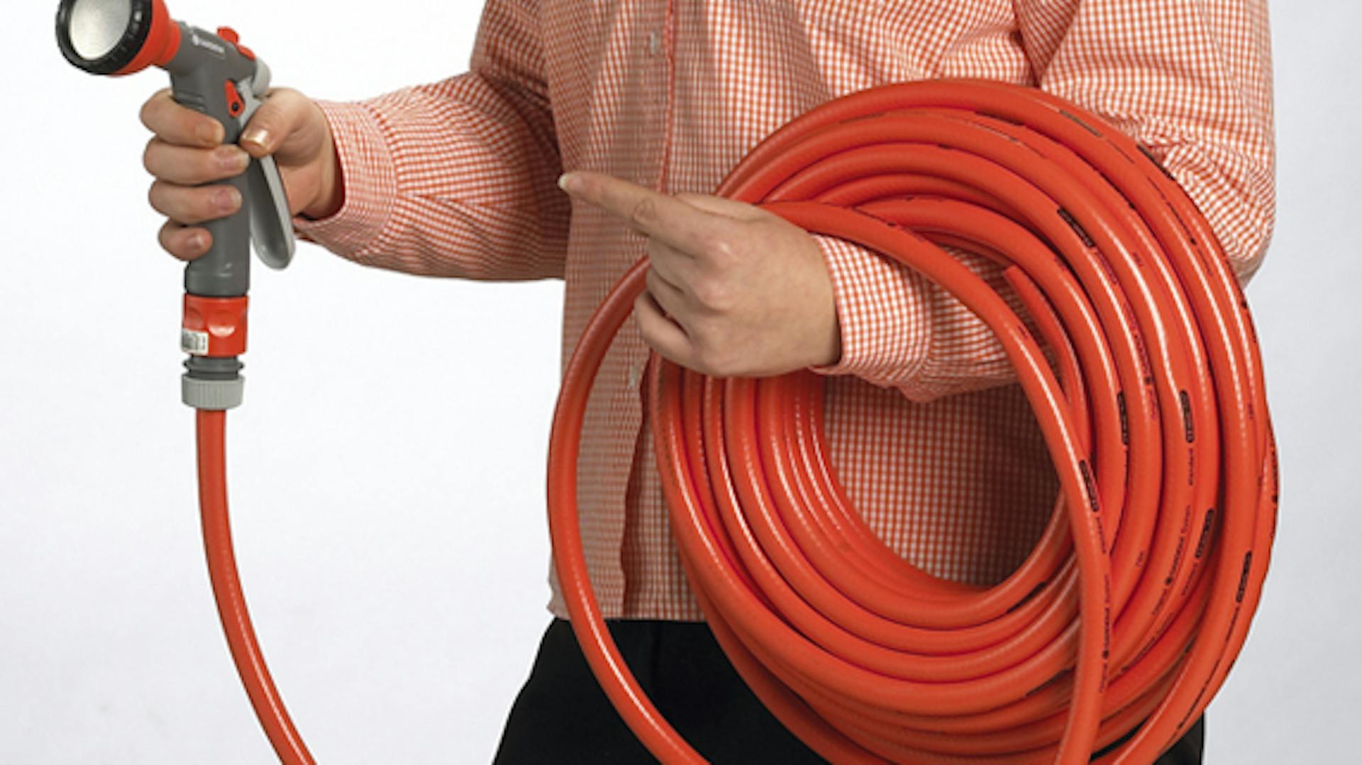Jemand hält einen aufgerollten Gartenschlauch mit Brause.