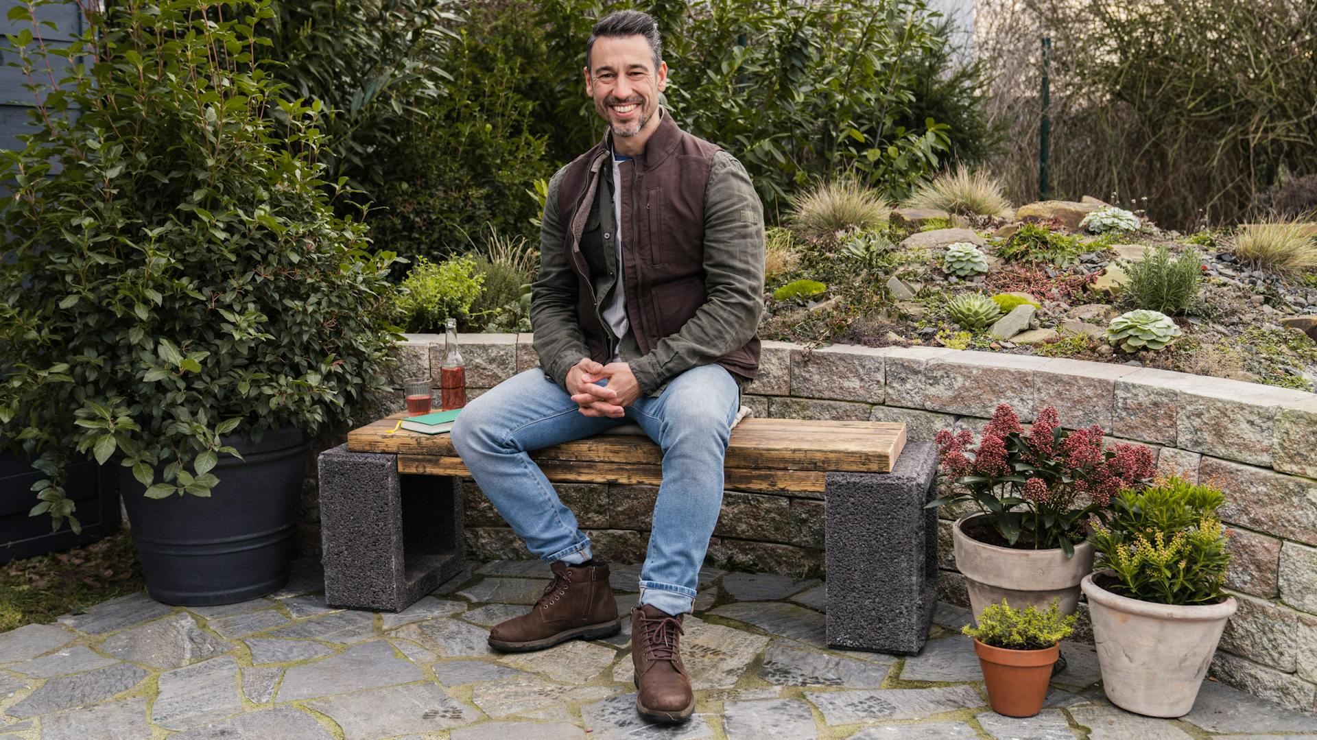 Davit Arican kerttervező ül egy kerti padon