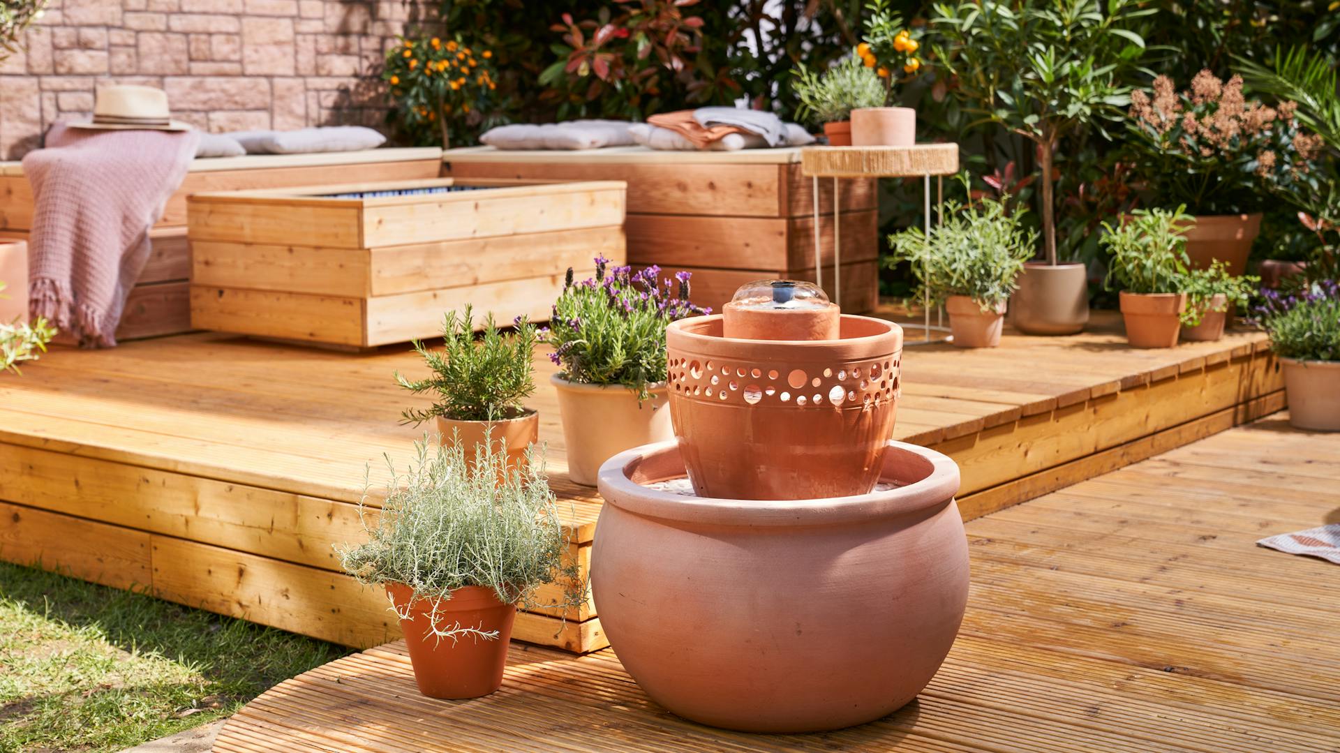 Csobogó terrakotta cserepekből a cserepes növények és a terasz mellett