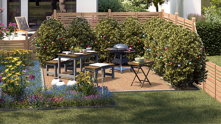 Gartengestaltung natürlicher Sitzplatz mit Sitzgruppe aus Holz und Metall an Grill auf Holzboden neben natürlich bepflanzten Beeten und geschmückten Bäumen