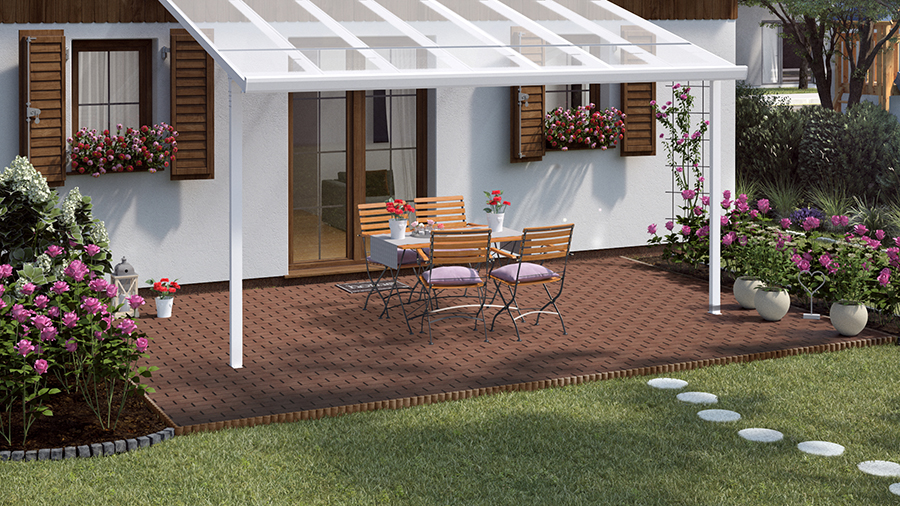 Gartengestaltung romantische Terrasse mit Sitzgruppe aus Holz und Metall auf Natursteinboden unter weißem Sonnenschutz neben üppig bepflanzten Rosenbeeten