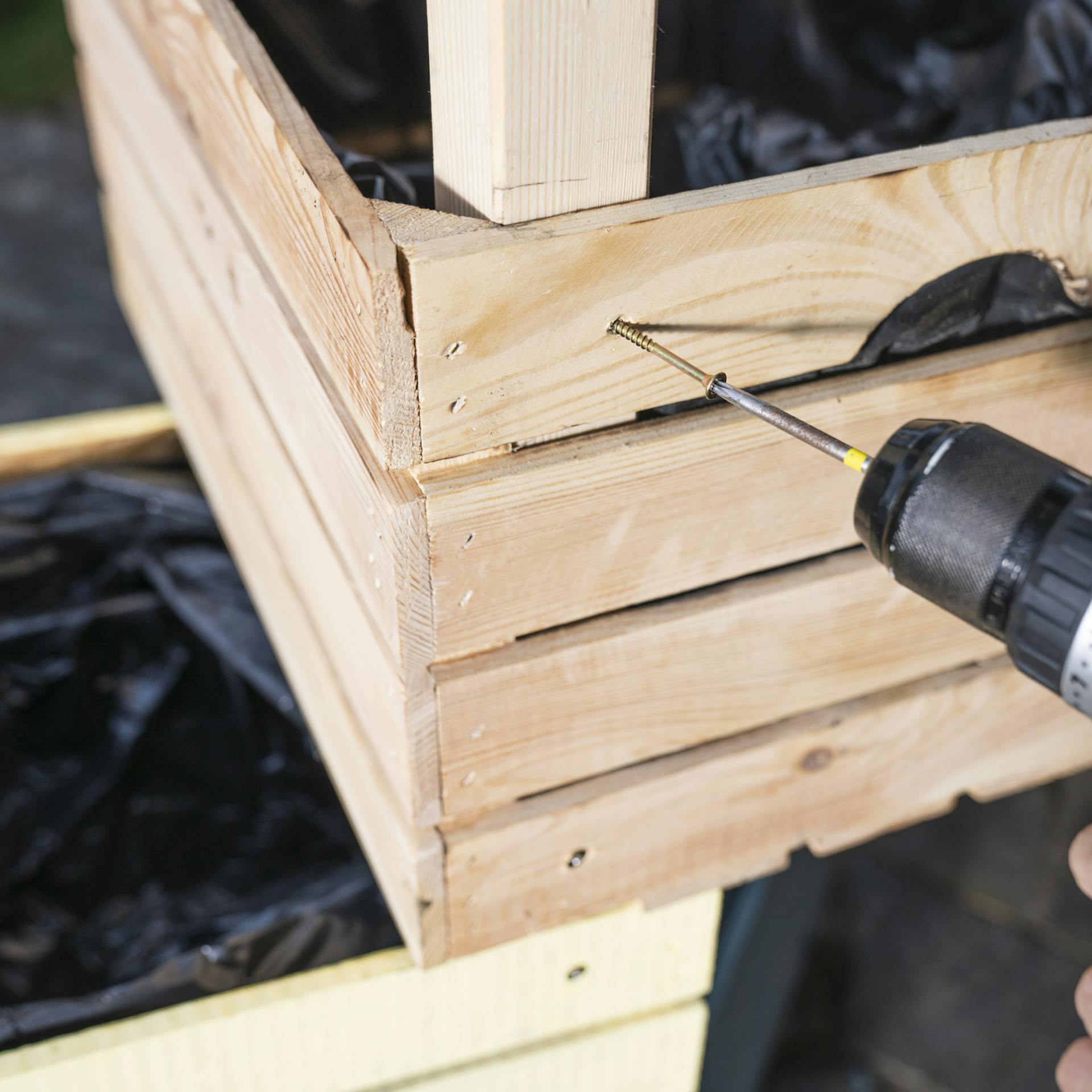 Die obere Pflanzkiste wird von außen mit einer Schraube befestigt.
