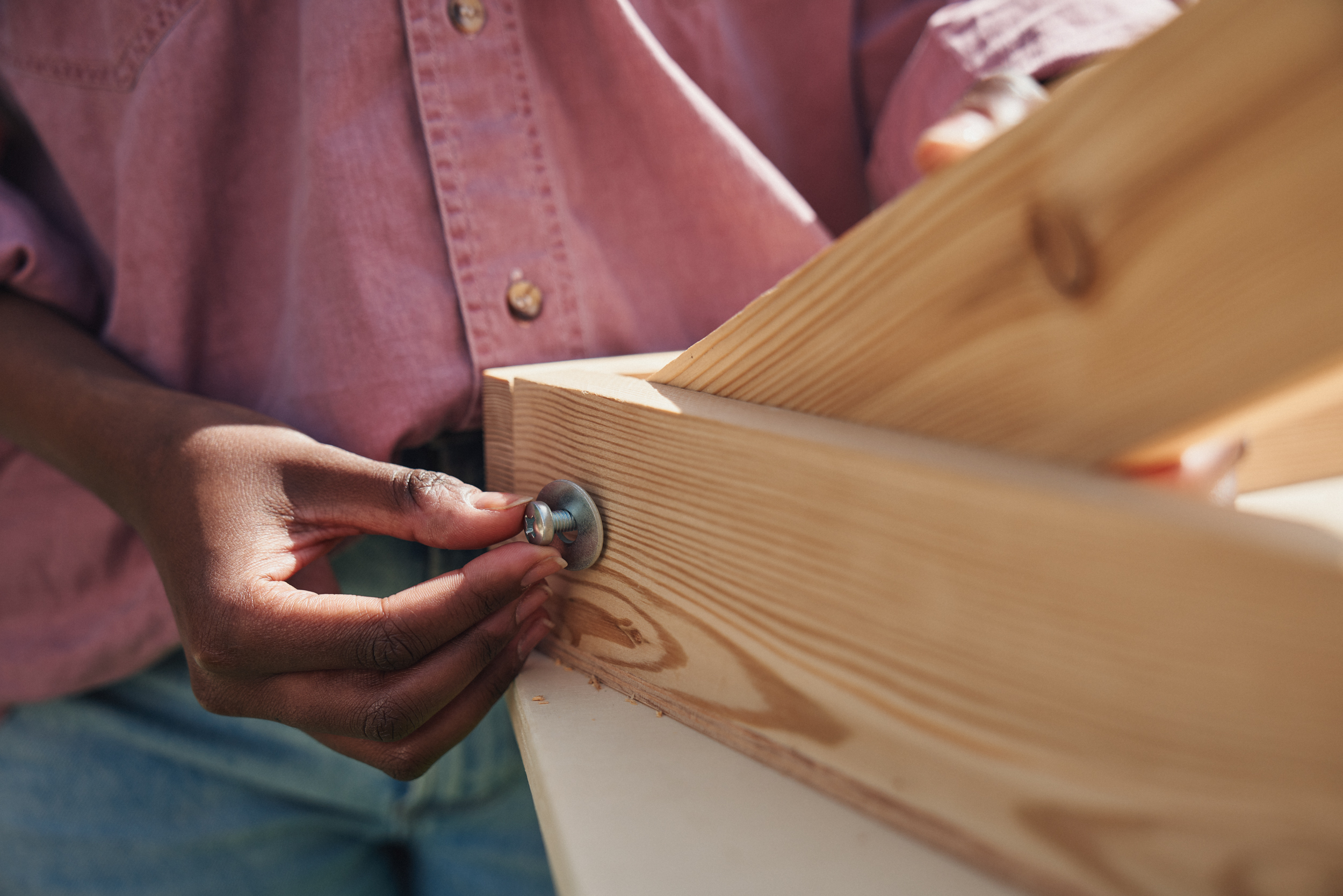 Egy nő rögzíti a deszka lábát az állványzathoz.