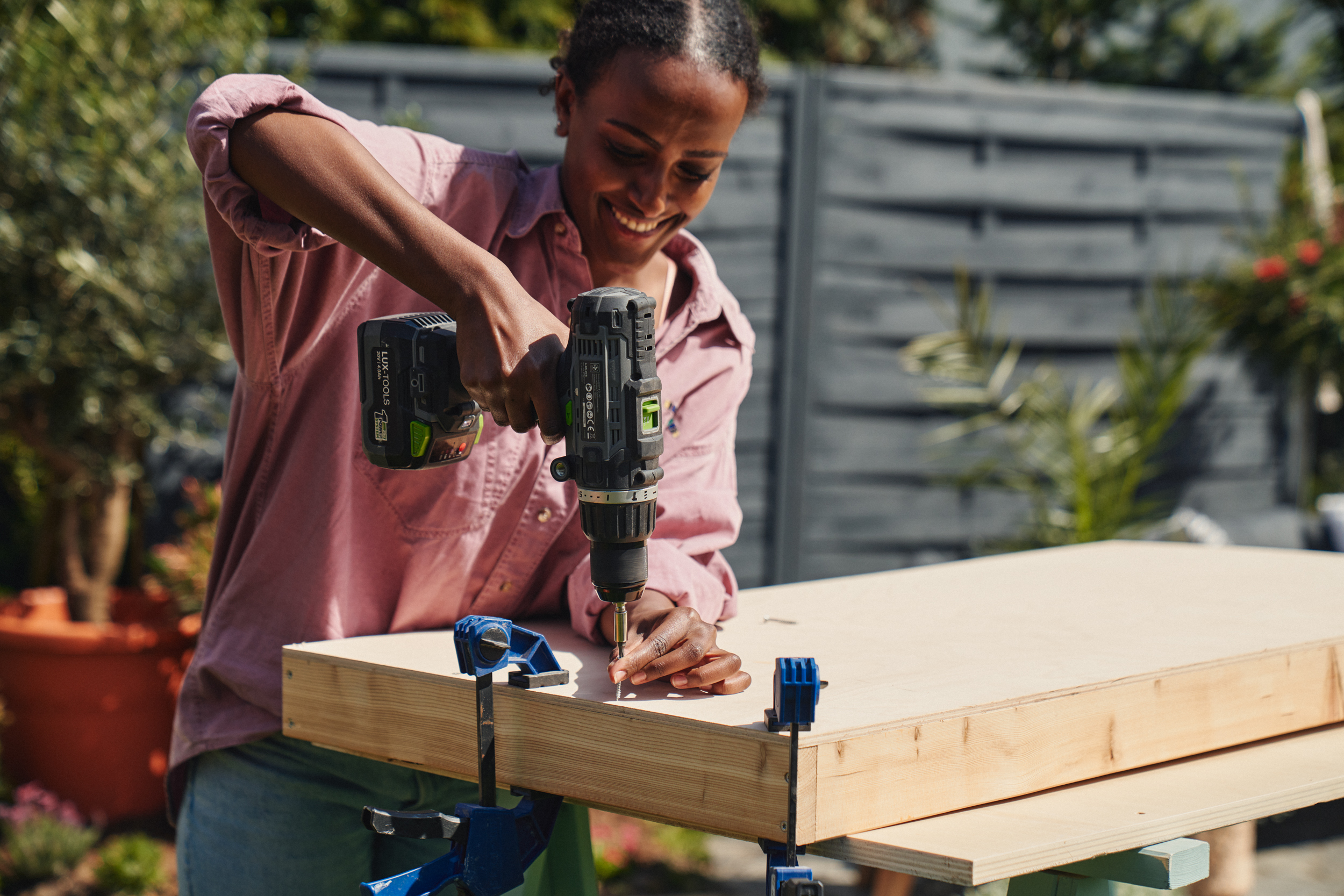 A nő a másik oldalról becsavarja a tábla alapkeretét.