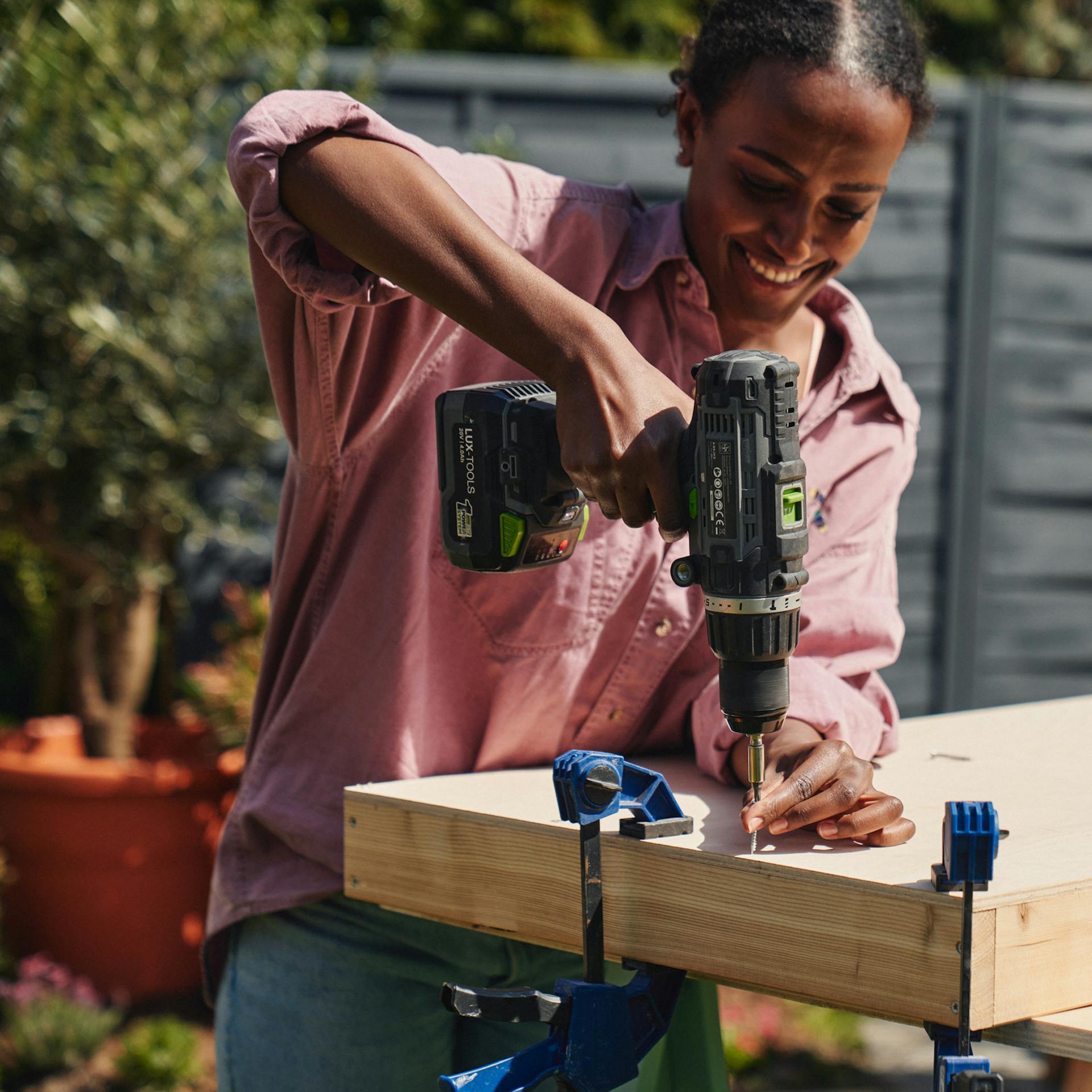 A nő a másik oldalról becsavarja a tábla alapkeretét.