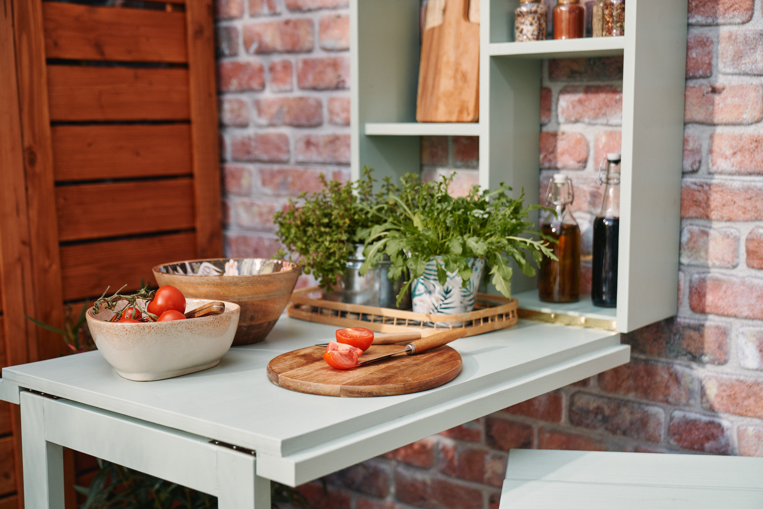 Rozložený grilovací stůl, na kterém se připravuje jídlo