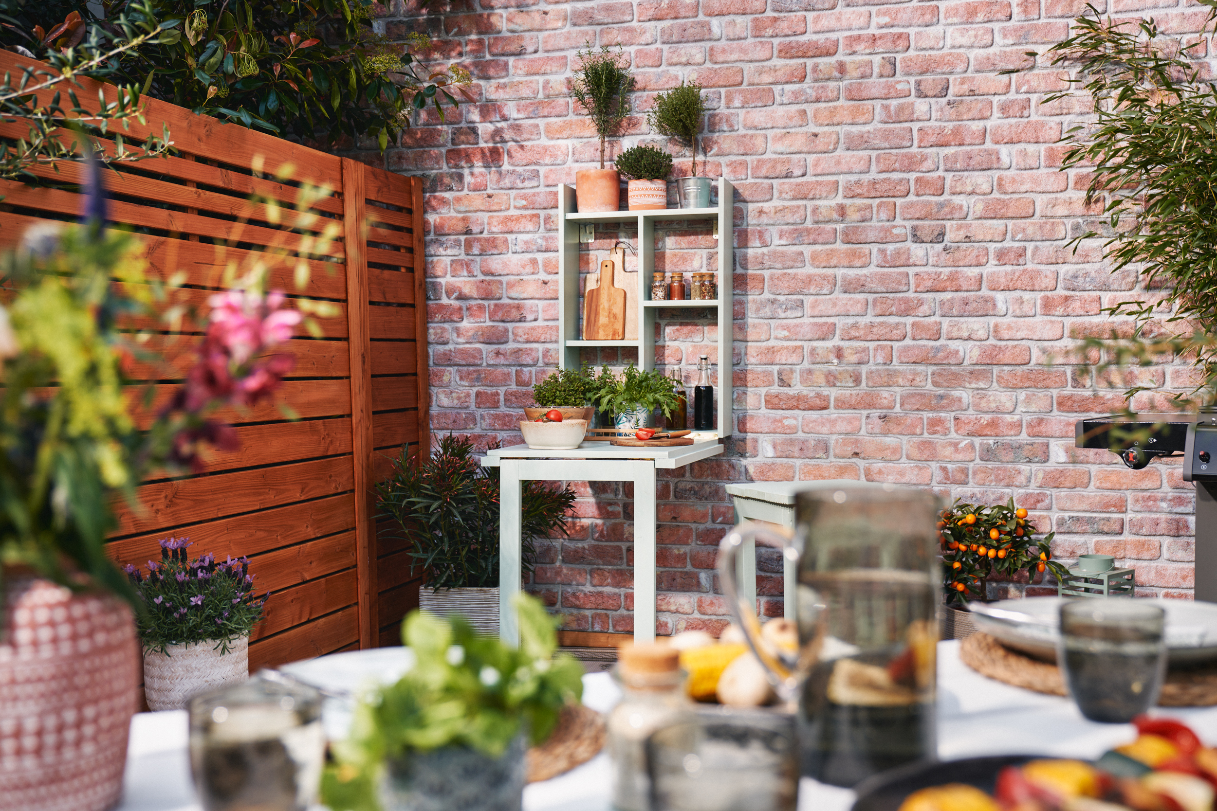 Rozložený grilovací stůl s prostřeným stolem a dekorací