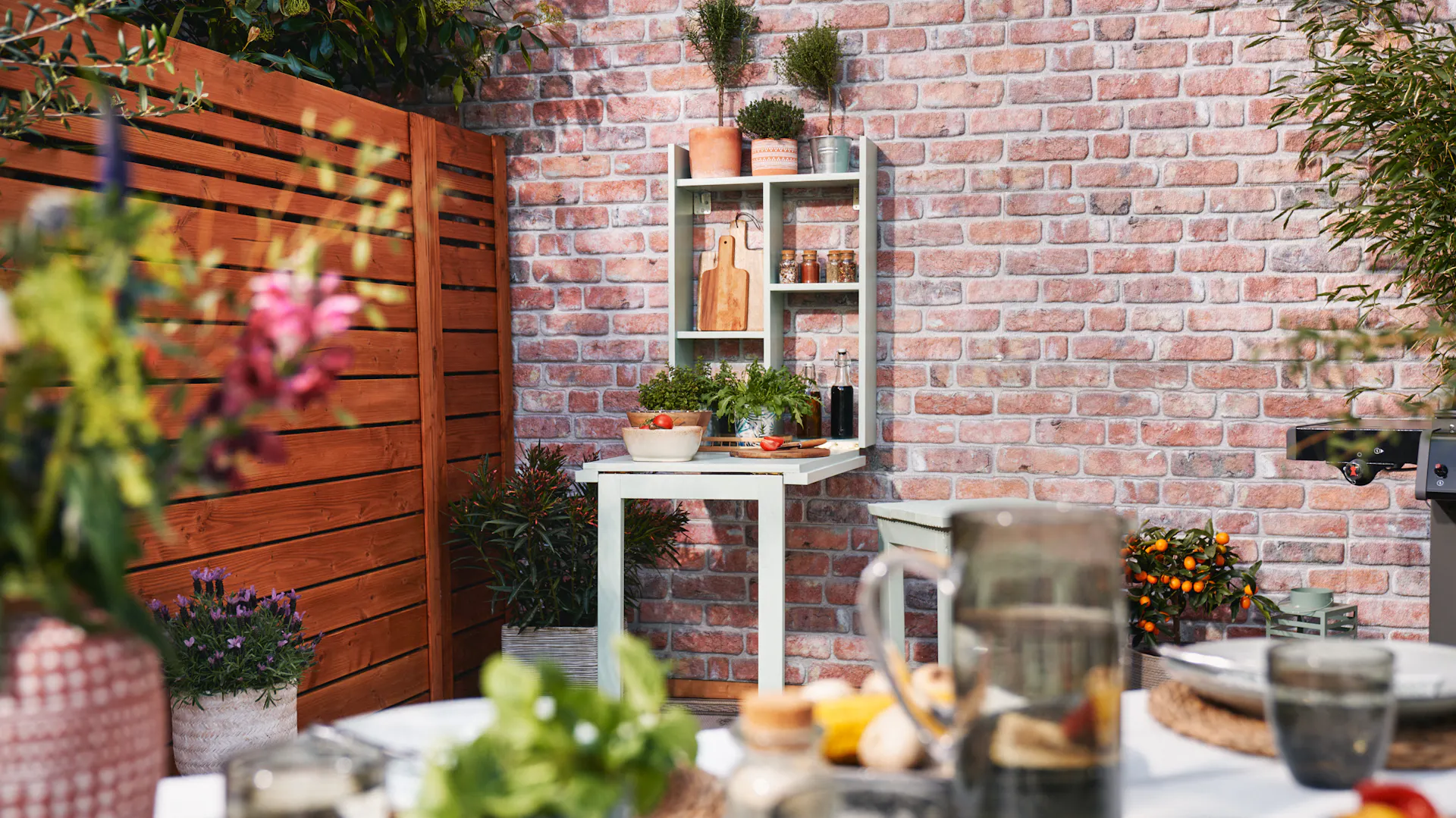 Rozložený grilovací stůl s prostřeným stolem a dekorací