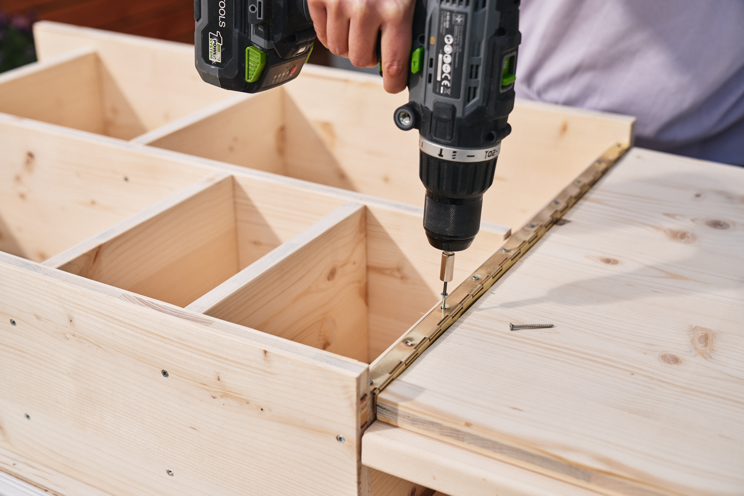 Další závěs je připevněn k polici a desce stolu