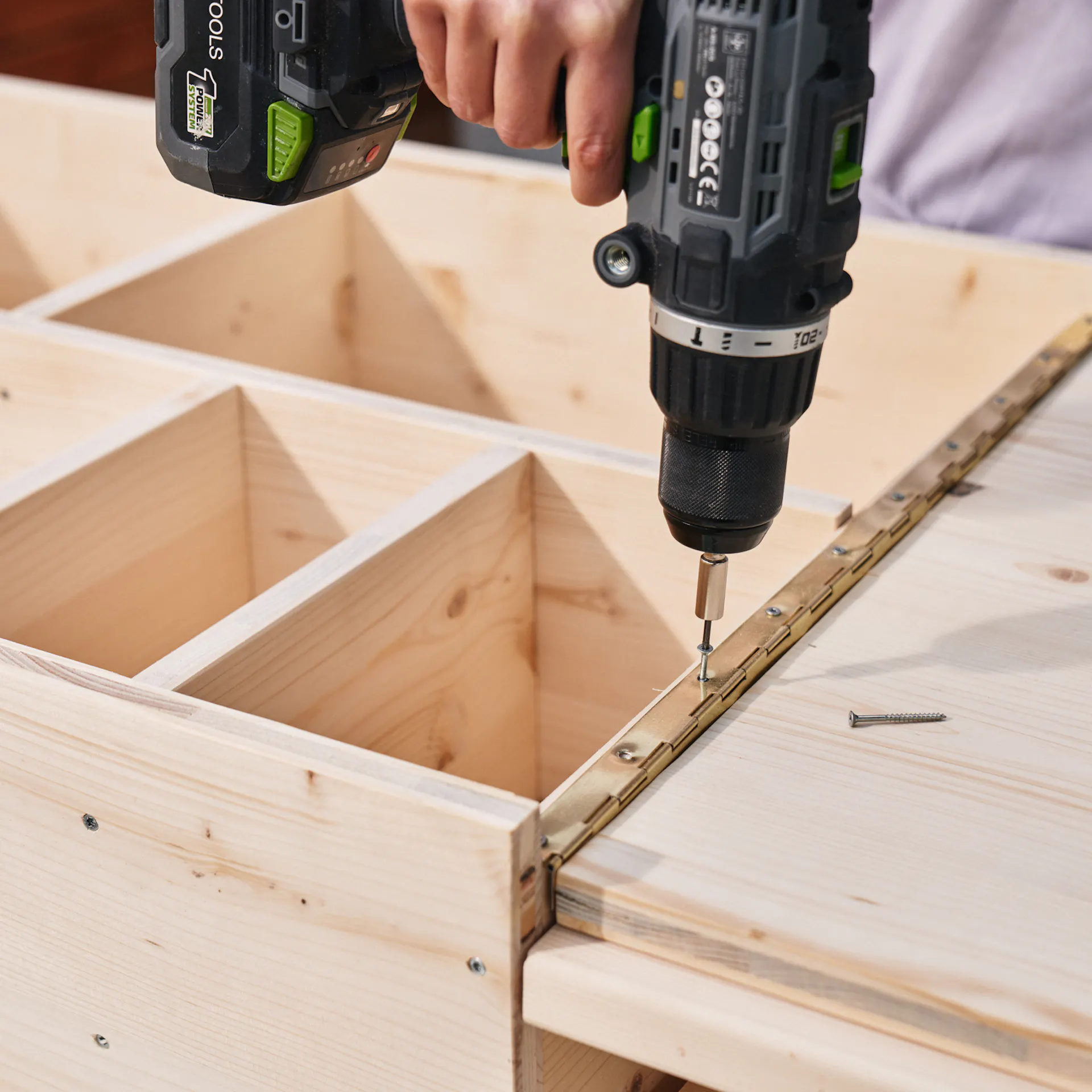 Další závěs je připevněn k polici a desce stolu