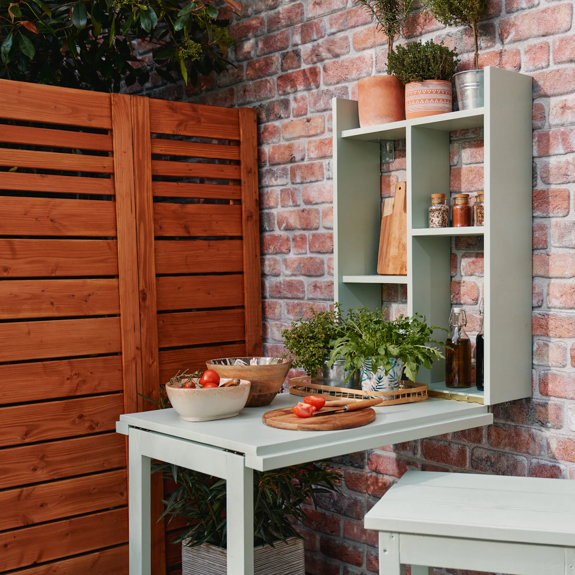 Hotový grilovací stůl, připevněný ke stěně domu s dekorací