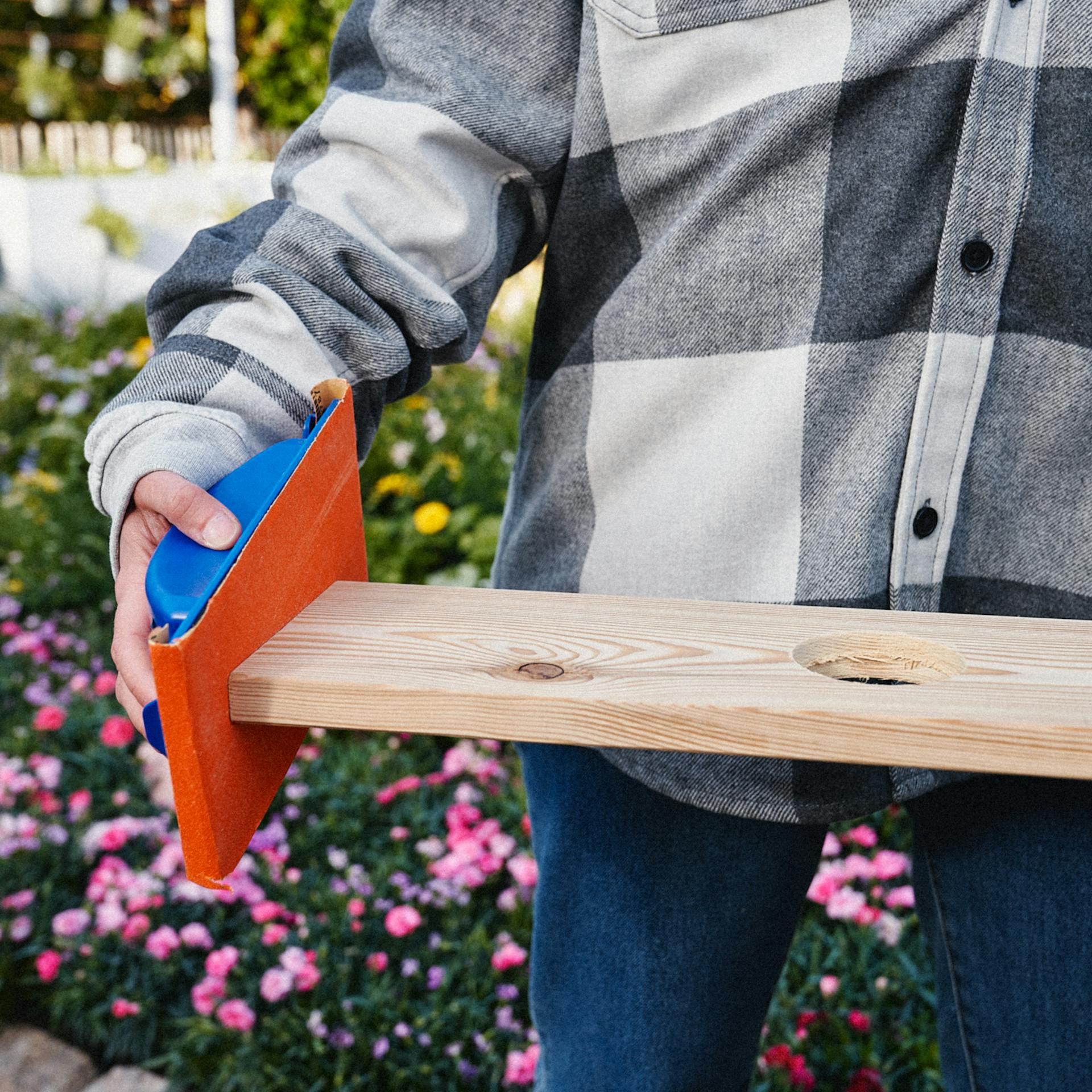 Mithilfe eines Schleifklotzes und Schleifpapier werden die Kanten entgratet