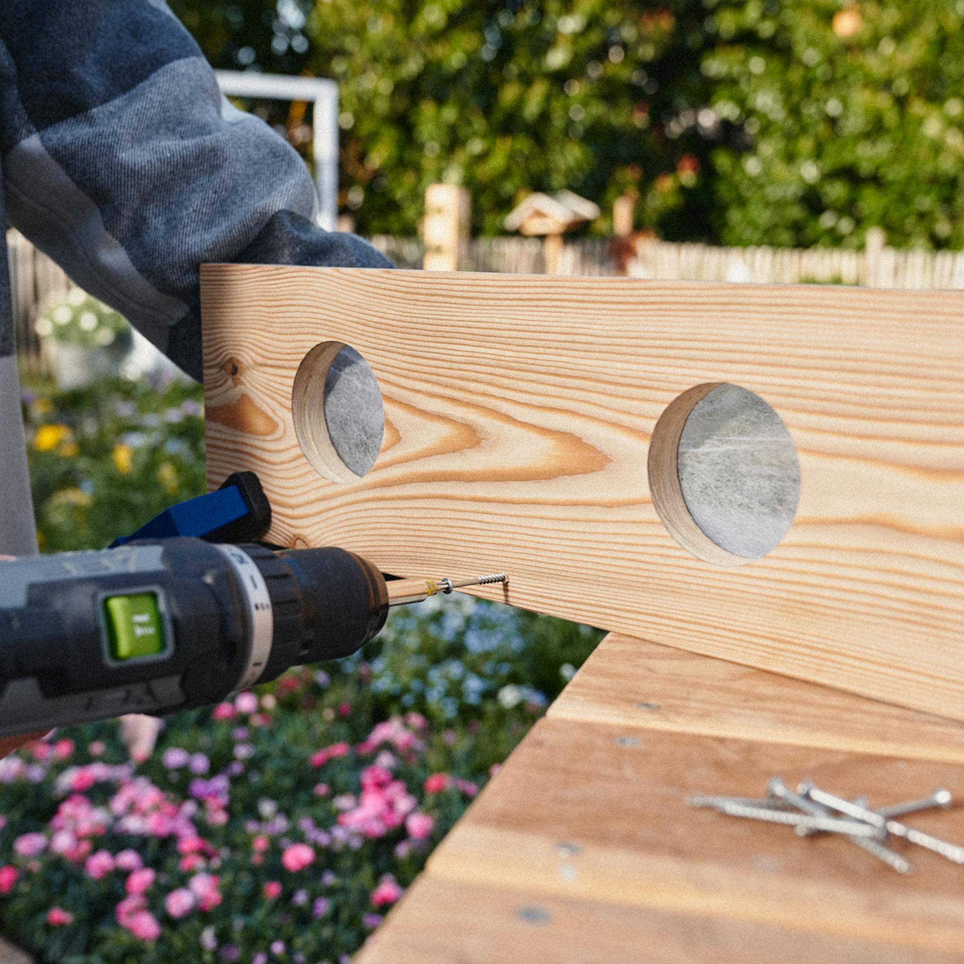 Mithilfe eines Akkubohrers, werden die Latten verschraubt