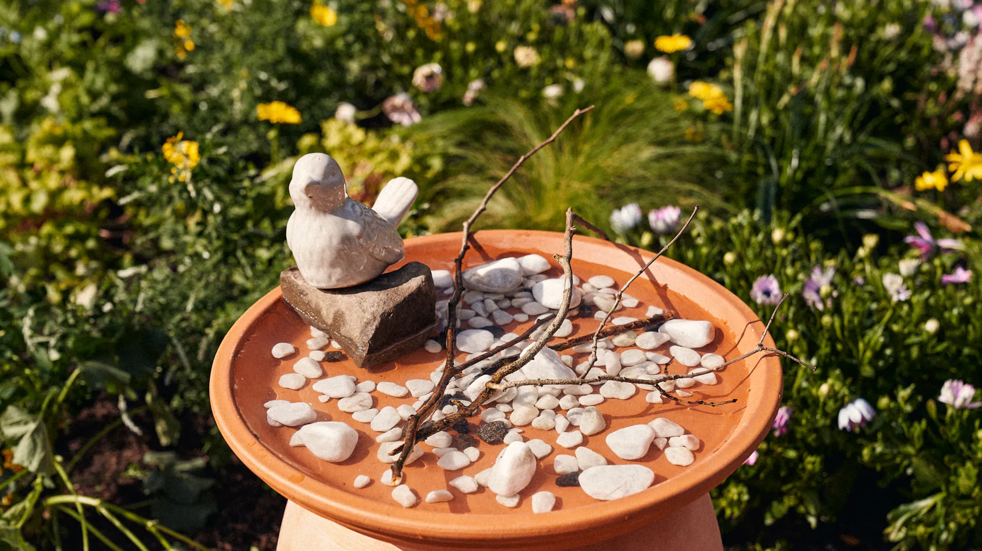 Ágakkal és kavicsokkal megtöltött madáritató.