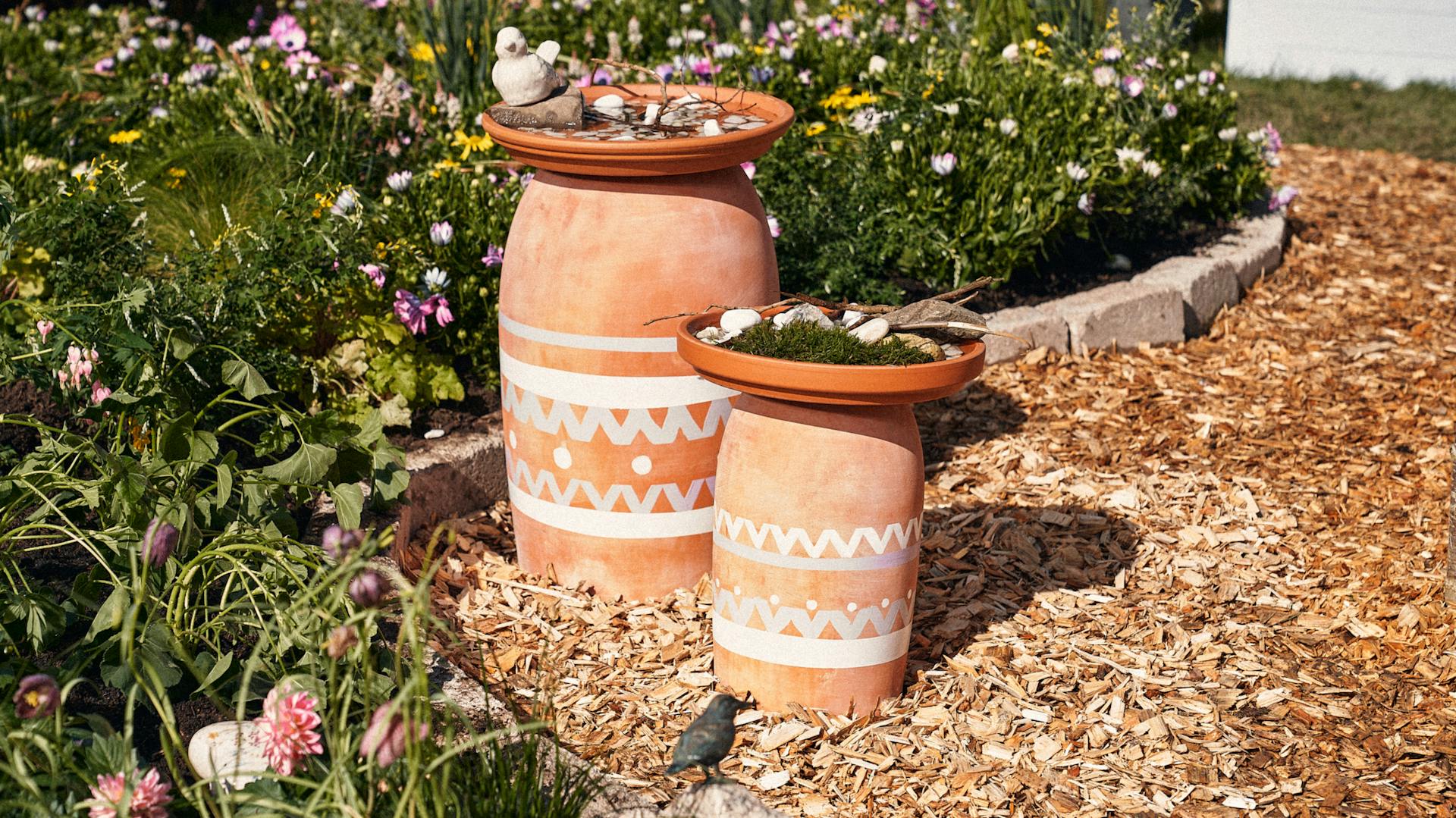 Tiertränken stehen im Garten auf einem Mulchweg.