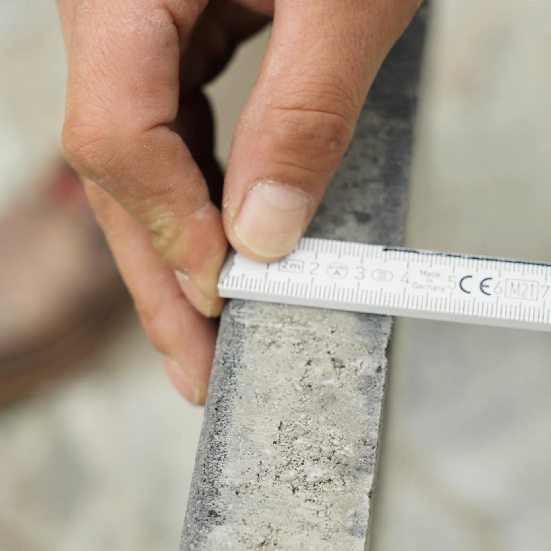 Zollstock wird an der Breite der Platte angehalten.