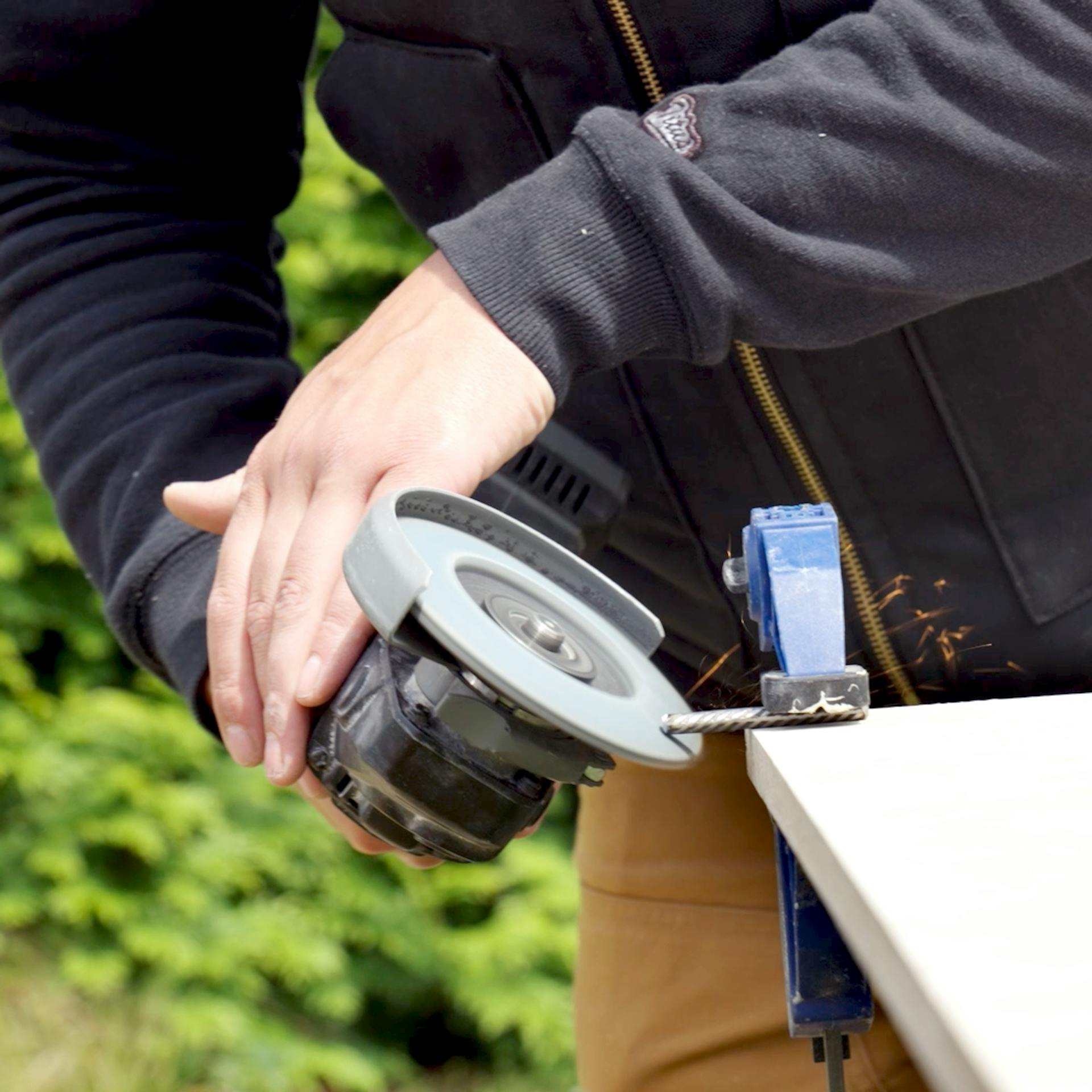 Handwerker schleif den Dübel mit einer Schruppscheibe.