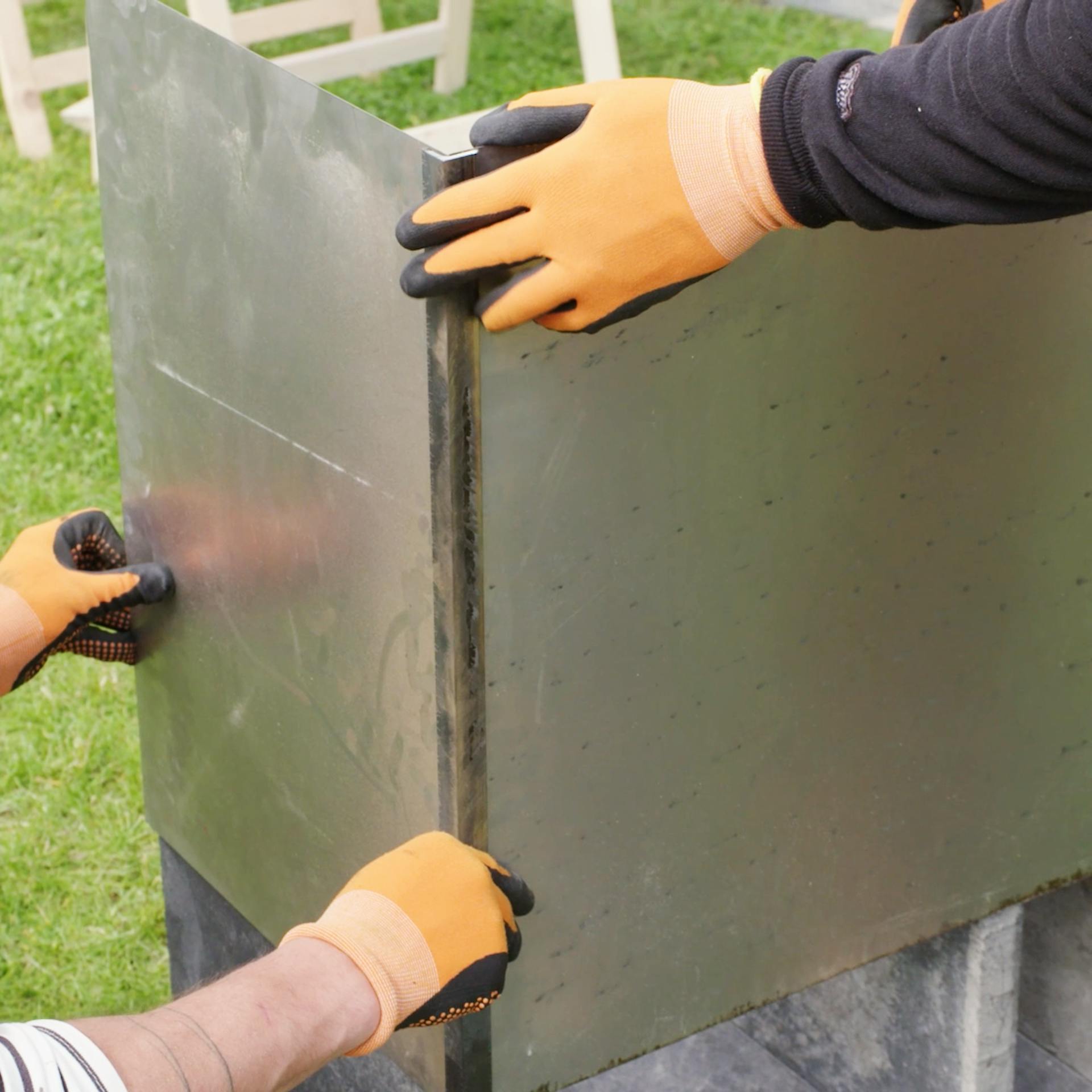 Handwerker bringen den Windschutz an dem Rahmen an.