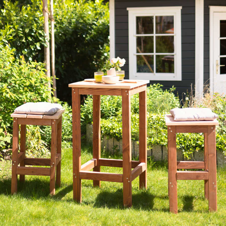 Sitzgruppe Ede Quadratisch in einem Garten vor einem Gartenhäuschen