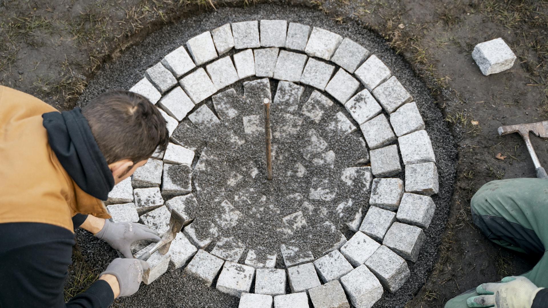 Mann pflastert eine Feuerstelle