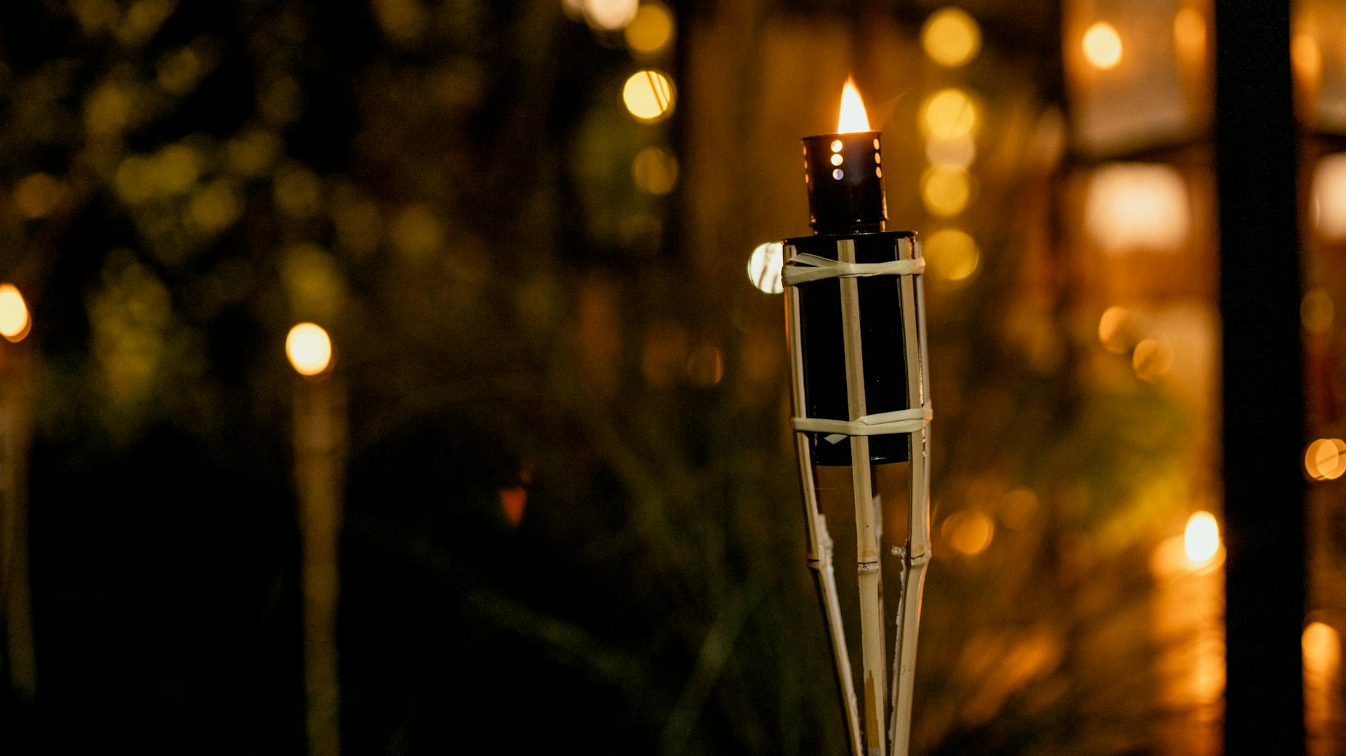 Eine brennende Bambusfackel bei Nacht.