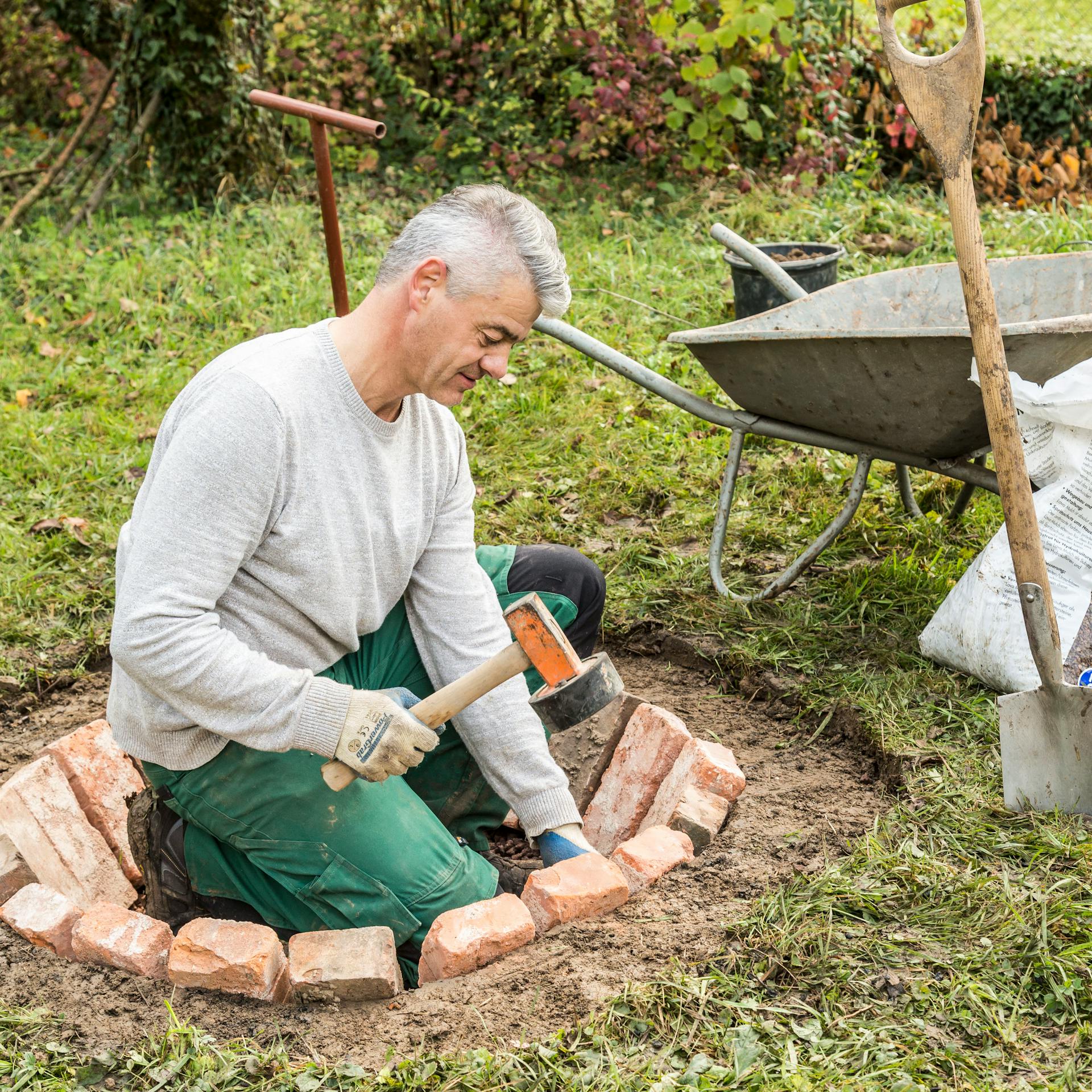 Osoba kladie kamene do ohniska.